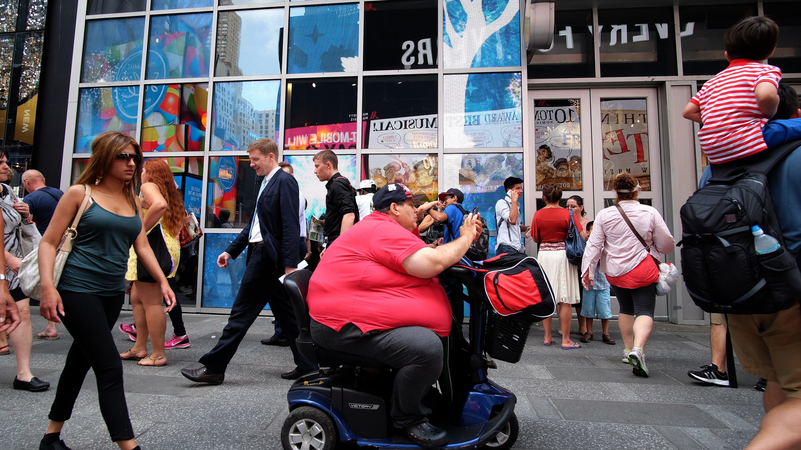 A man on an electric scooter makes his way with other pedestrians in New York on July 1, 2015. (Credit: Jewel Samad / AFP / Getty Images)