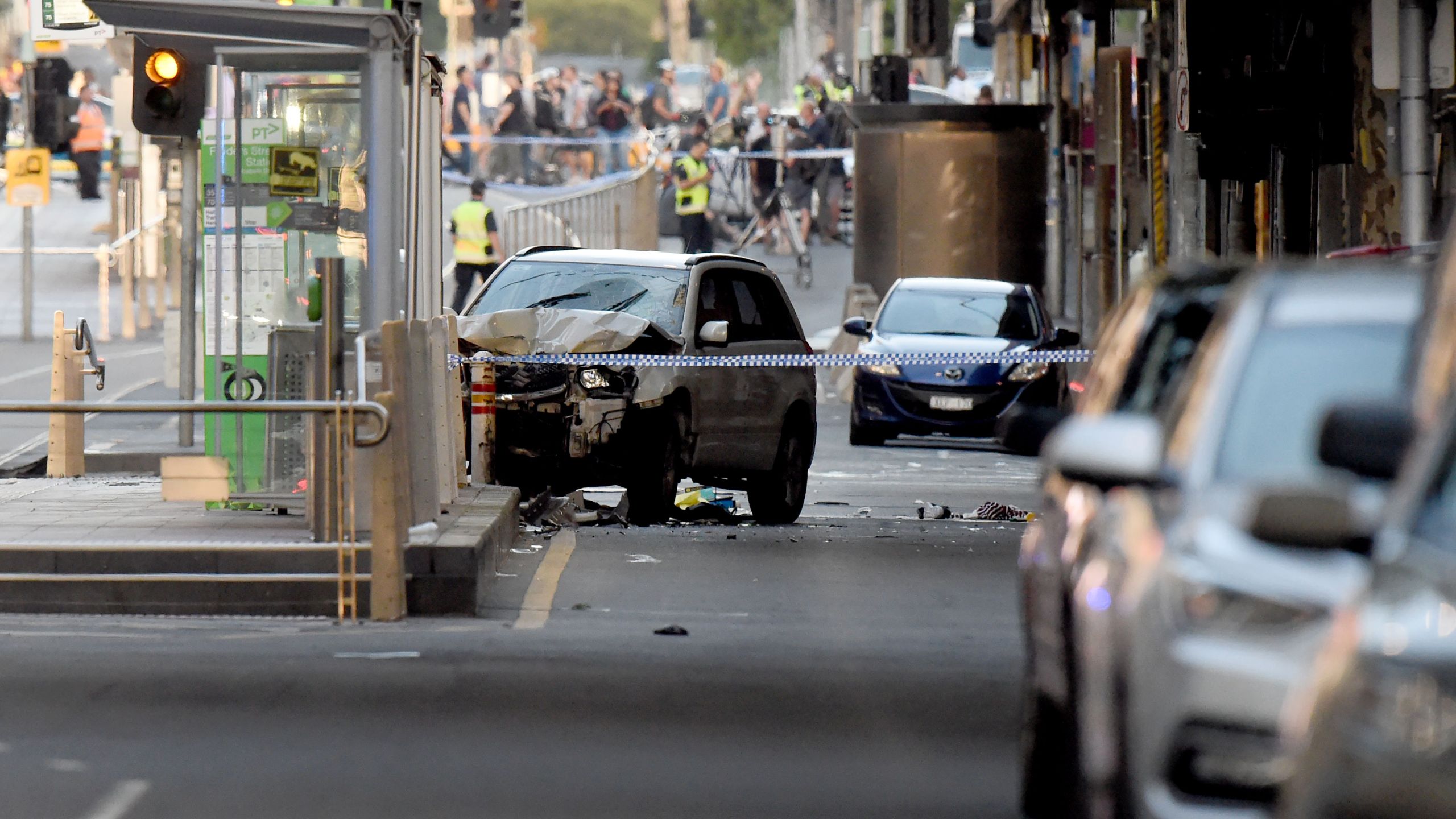 A white SUV sits in the middle of the road as police and emergency personnel work at the scene of where a car ran over pedestrians in Melbourne on December 21, 2017. (Credit: MAL FAIRCLOUGH/AFP/Getty Images)
