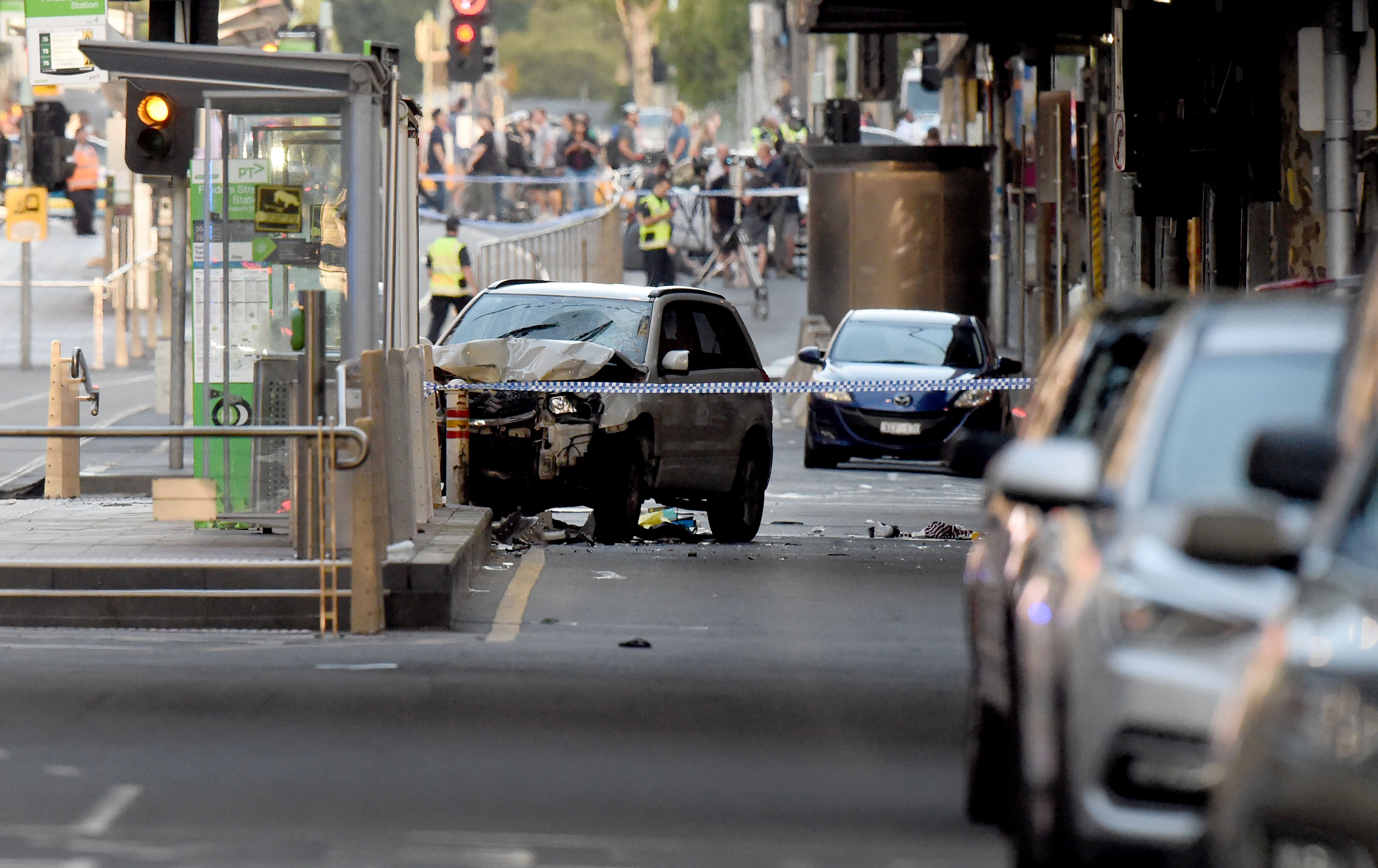 A white SUV sits in the middle of the road as police and emergency personnel work at the scene of where a car ran over pedestrians in Melbourne on December 21, 2017. (Credit: MAL FAIRCLOUGH/AFP/Getty Images)