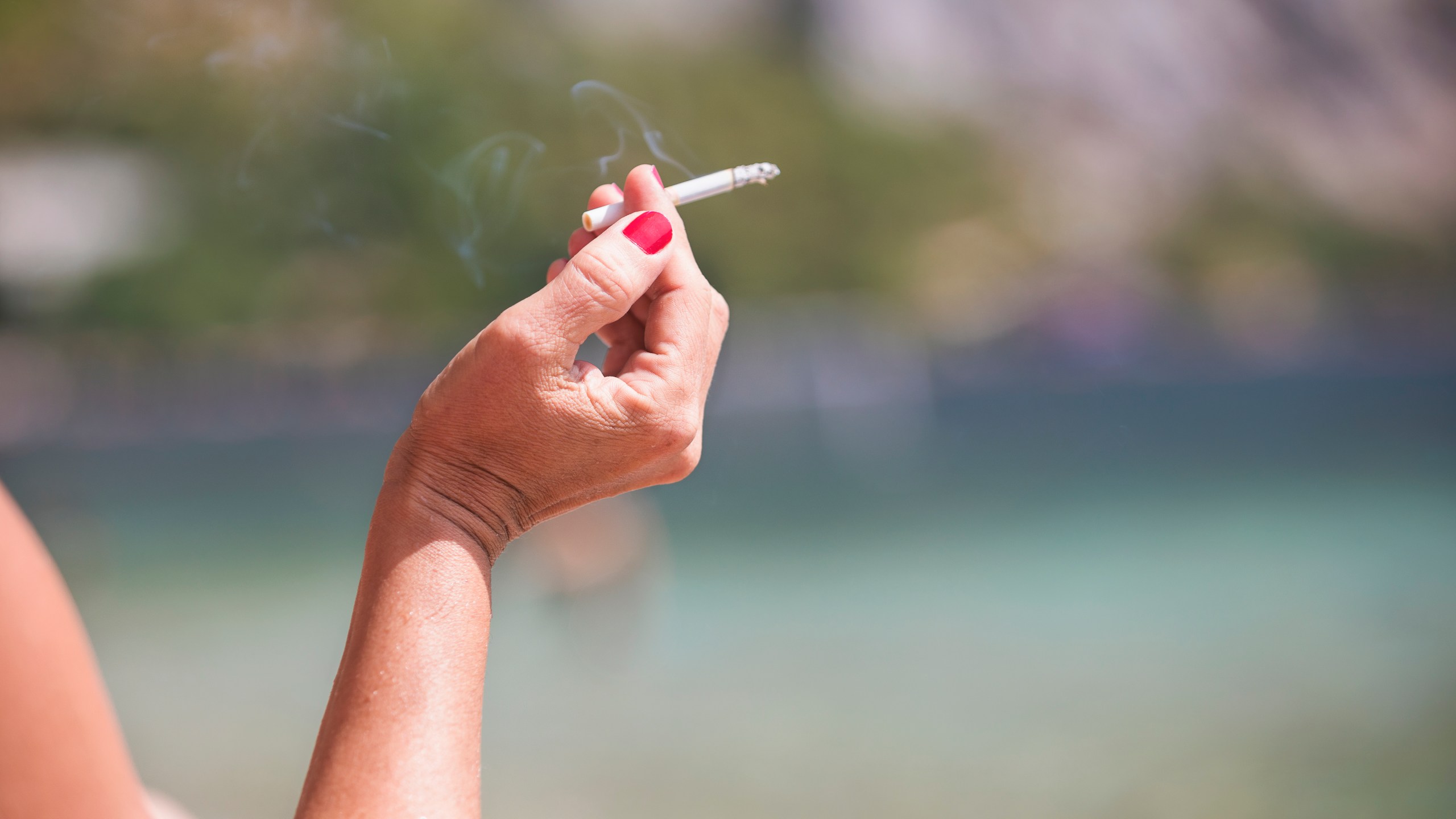A woman holding a cigarette is seen in this file photo. (Credit: iStock/Getty Images Plus)