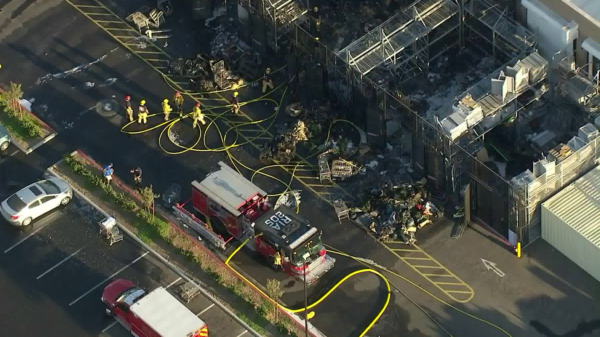 Firefighters clean up debris after a Walmart in Rialto burned on Sept. 21, 2018. (Credit: KTLA)