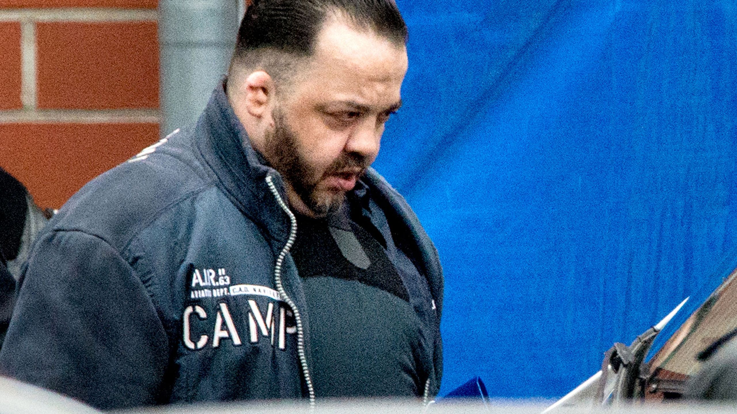 Former nurse Niels Hoegel, accused of killing more than 100 patients in his care, wears a bullet proof vest as he is lead out of the court compound towards a prisoner's transport vehicle, on October 2018 in Oldenburg, northern Germany, after the first day of his trial. (Credit: HAUKE-CHRISTIAN DITTRICH/AFP/Getty Images)