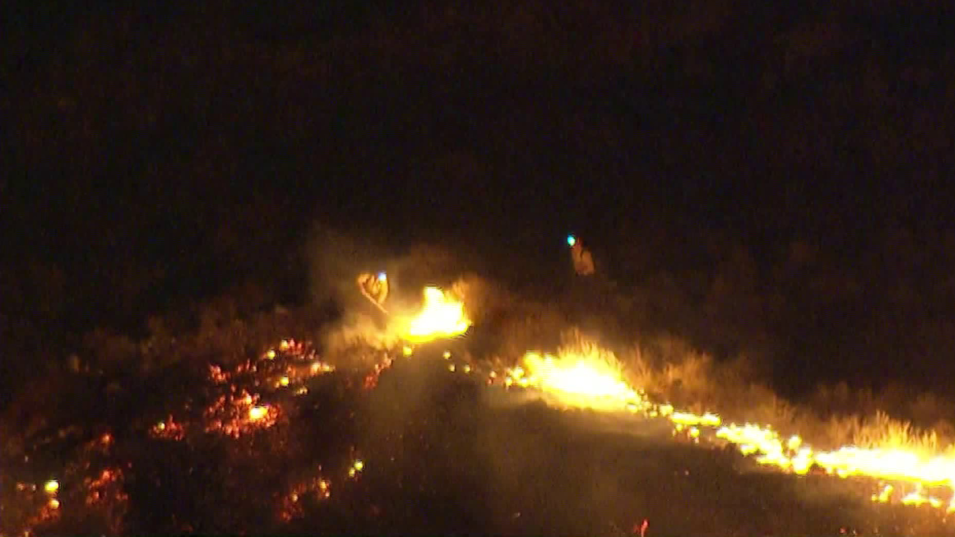 Firefighters work to build containment lines as a brush fire spreads rapidly in the hills above Fontana on Nov. 13, 2018. (Credit: KTLA)