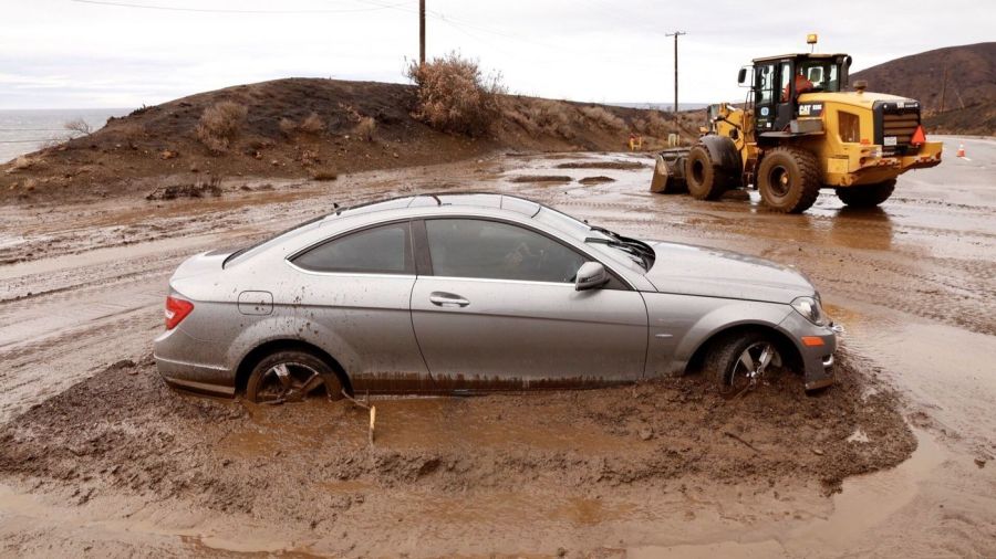 On the morning of Dec. 6, 2018, a car is seen stuck in packed up mud along the Pacific Coast Highway in Malibu after heavy rains hit the Southland and caused mudslides. (Credit: Al Seib/ Los Angeles Times)