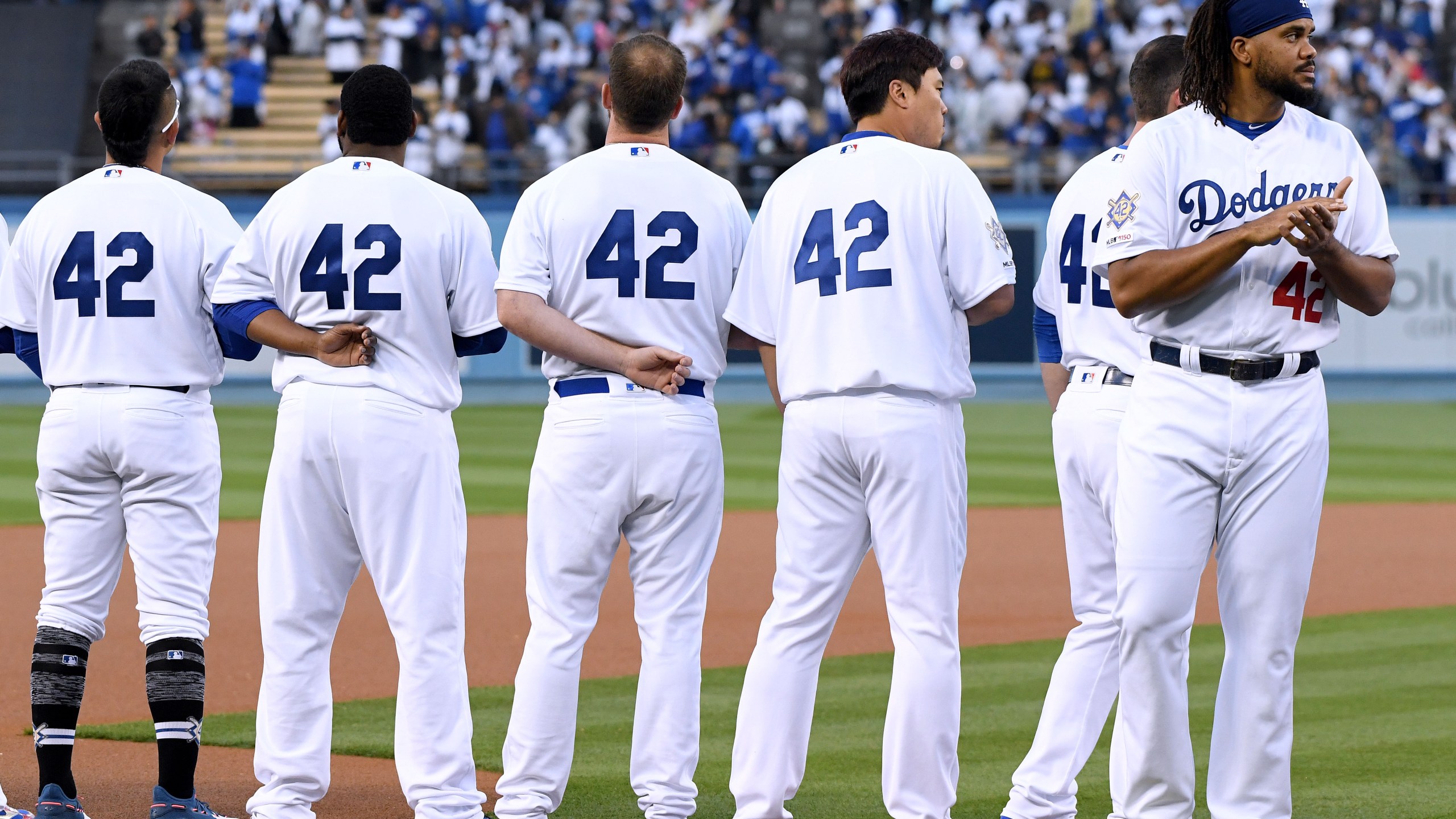 Kenley Jansen, far right, and other members of the Los Angeles Dodgers line up for the National Anthem before a game against the Cincinnati Reds on Jackie Robinson Day at Dodger Stadium on April 15, 2019. (Credit: Harry How / Getty Images)