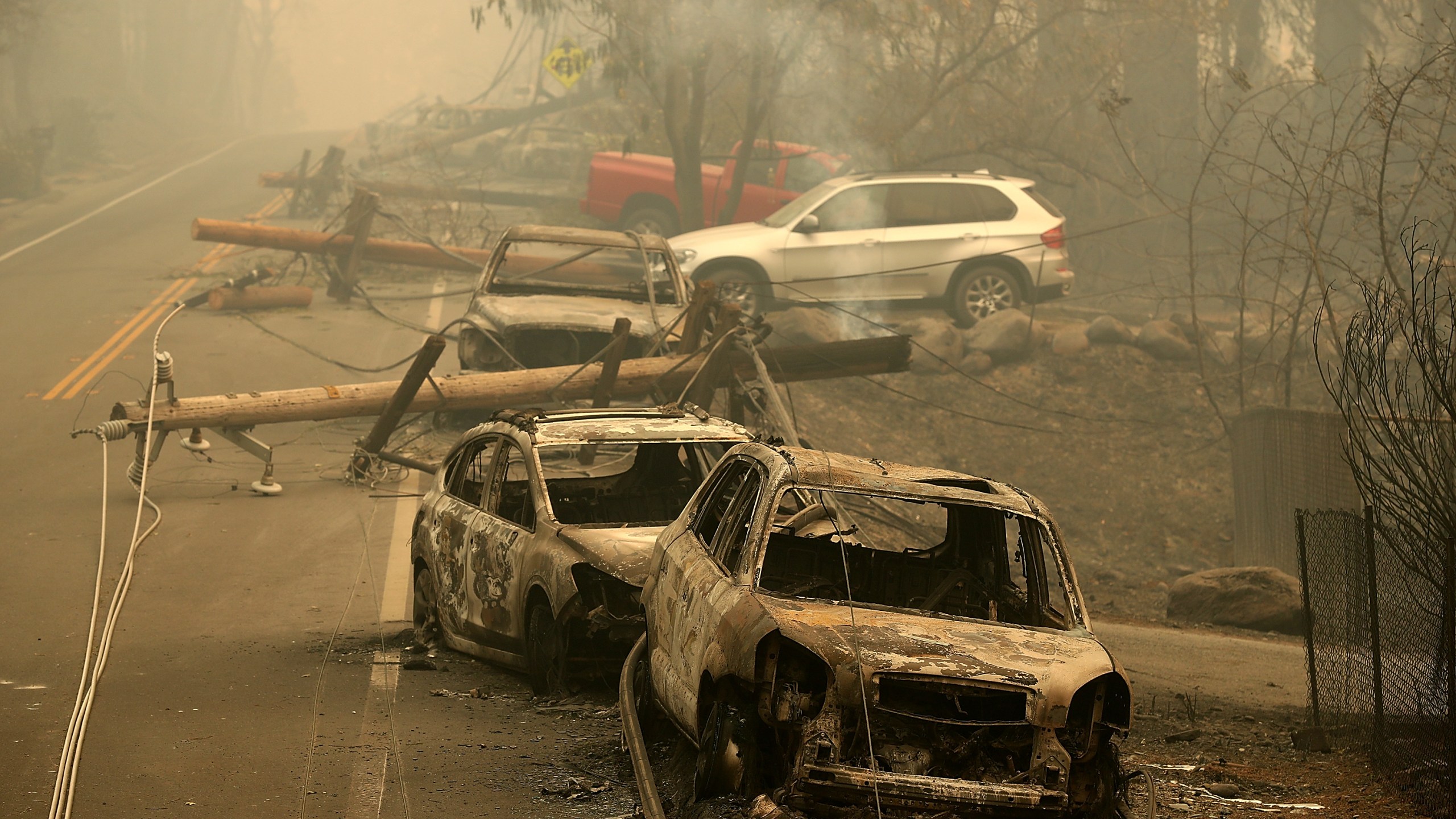 Power lines rest on cars that were burned by the Camp Fire on Nov. 10, 2018 in Paradise, California. (Credit: Justin Sullivan/Getty Images)