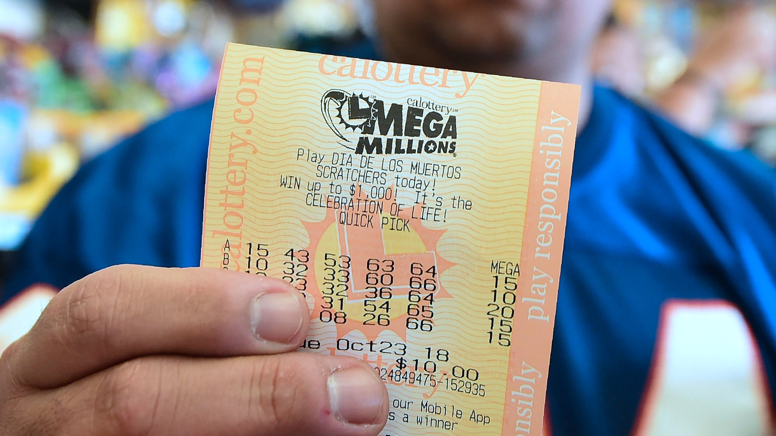 A man shows his just purchased lottery tickets from the Blue Bird Liquor store in Hawthorne, California on October 23, 2018. (Credit: FREDERIC J. BROWN/AFP/Getty Images)