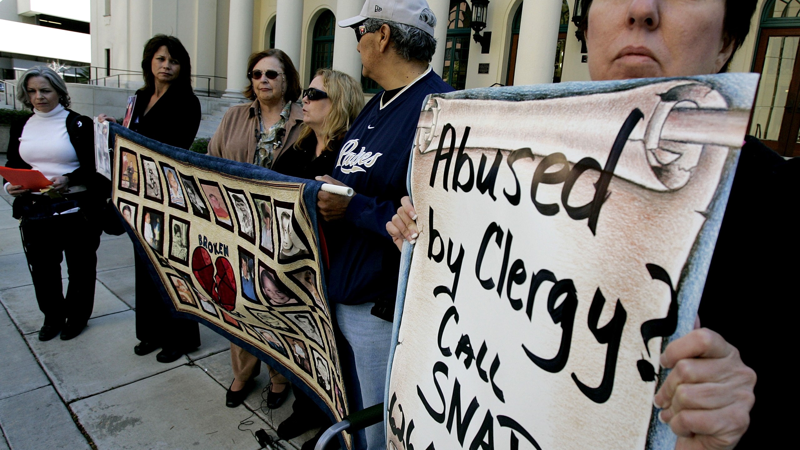 Protestors and alleged sexual abuse victims stand outside of The Jacob Weinburg Couthouse during a vigil to bring attention to victims of sexual abuse by religious leaders within the Catholic church on March 1, 2007 in San Diego, California. (Credit: Sandy Huffaker/Getty Images)