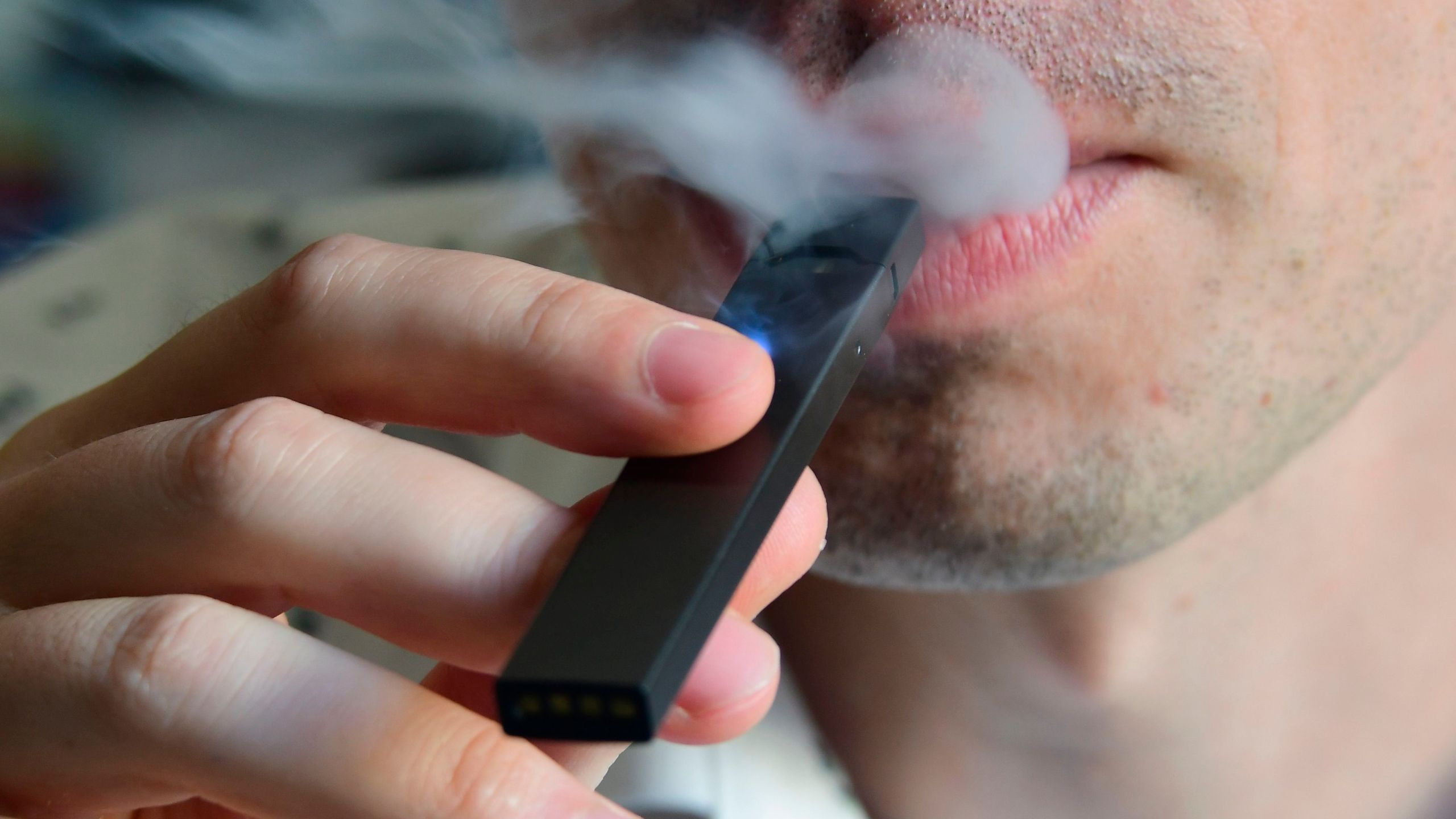 An illustration shows a man exhaling smoke from an electronic cigarette in Washington, D.C., on Oct. 2, 2018. (Credit: Eva Hambach / AFP / Getty Images)