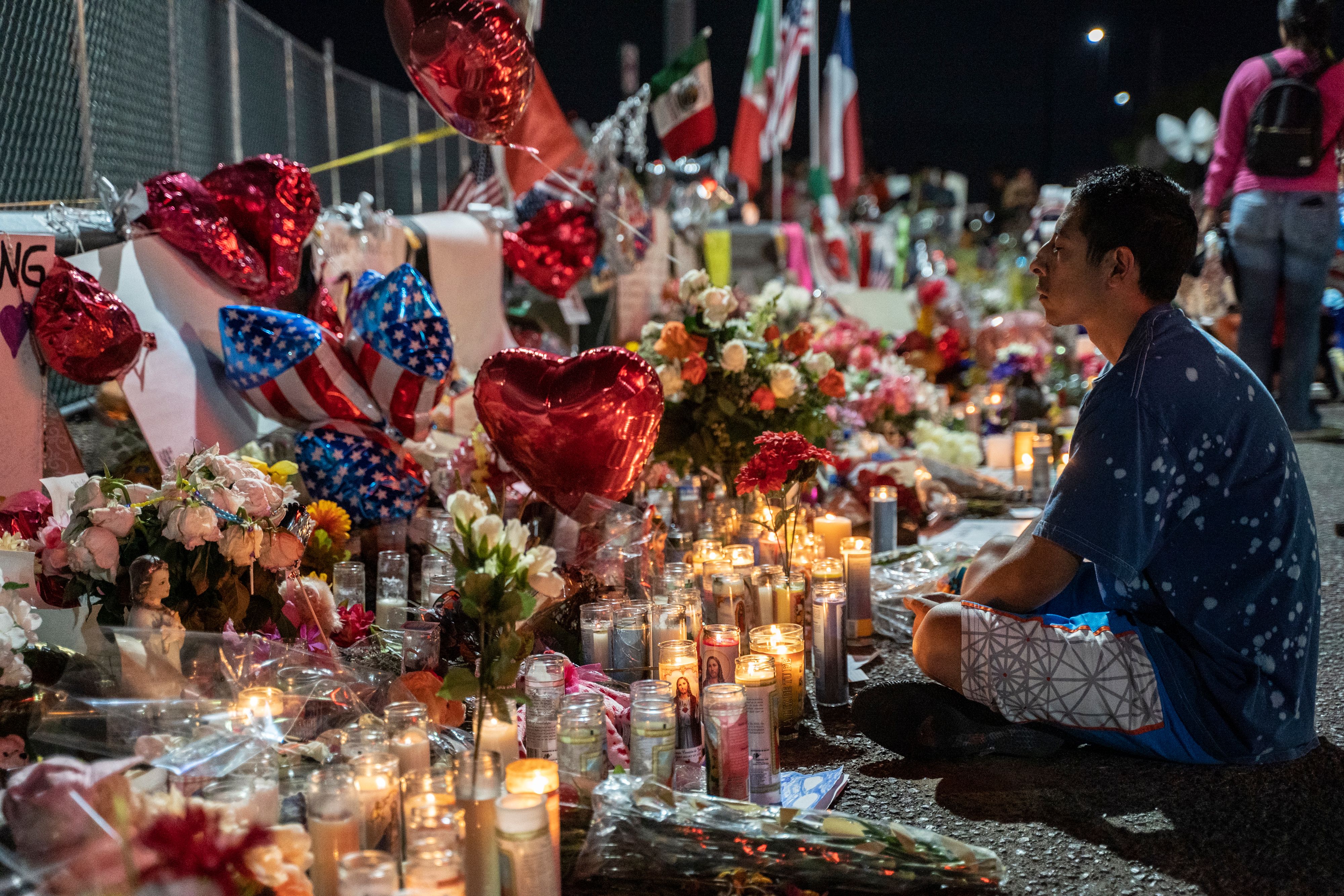 Abel Valenzuela, an El Paso local, meditates in front of the makeshift memorial for shooting victims at the Cielo Vista Mall Walmart in El Paso, Texas, on Aug. 8, 2019. (Credit: Paul Ratje / AFP / Getty Images)