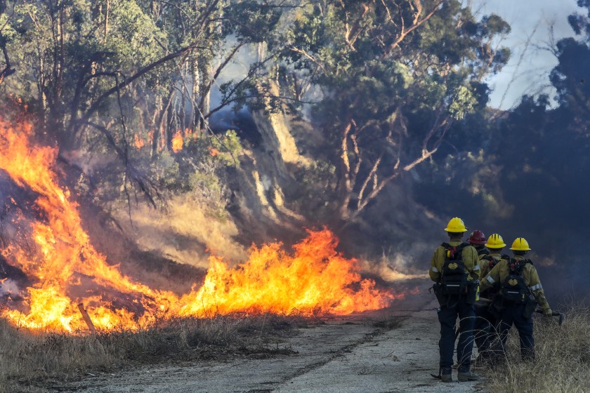 Firefighters kept an eye on the Saddleridge fire burning behind a hospital in Slymar on Oct. 11, 2019. (Credit: Irfan Khan / Los Angeles Times)
