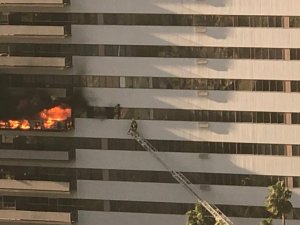 LAFD tweeted this image of a firefighter working to a rescue someone hanging outside Barrington Plaza amid a fire on Jan. 29, 2020. 