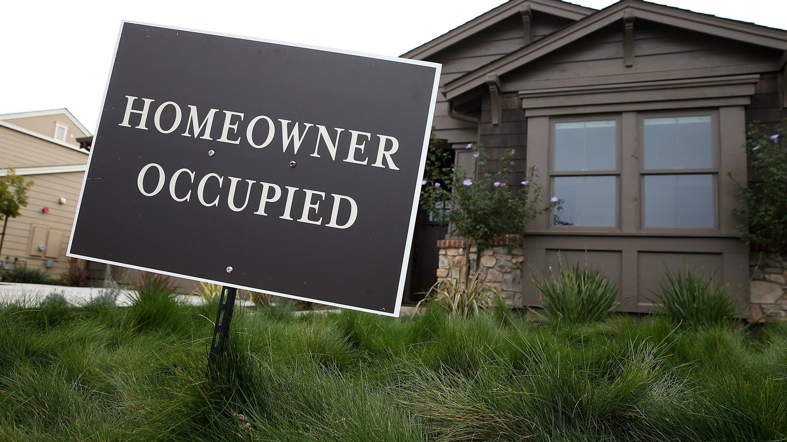 A homeowner occupied sign is posted in front of a recently purchased new home at the Rose Lane housing development in Lakespur on Jan. 27, 2015. (Credit: Justin Sullivan / Getty Images)