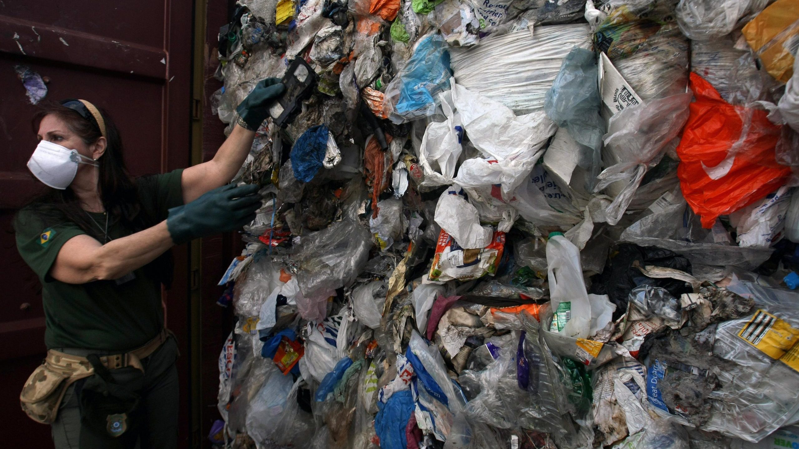 An agent inspects one of 41 containers carrying 1,400 tons of household waste shipped to Brazil from the United Kingdom on July 22, 2009. (Credit: Mauricio Lima /AFP via Getty Images)