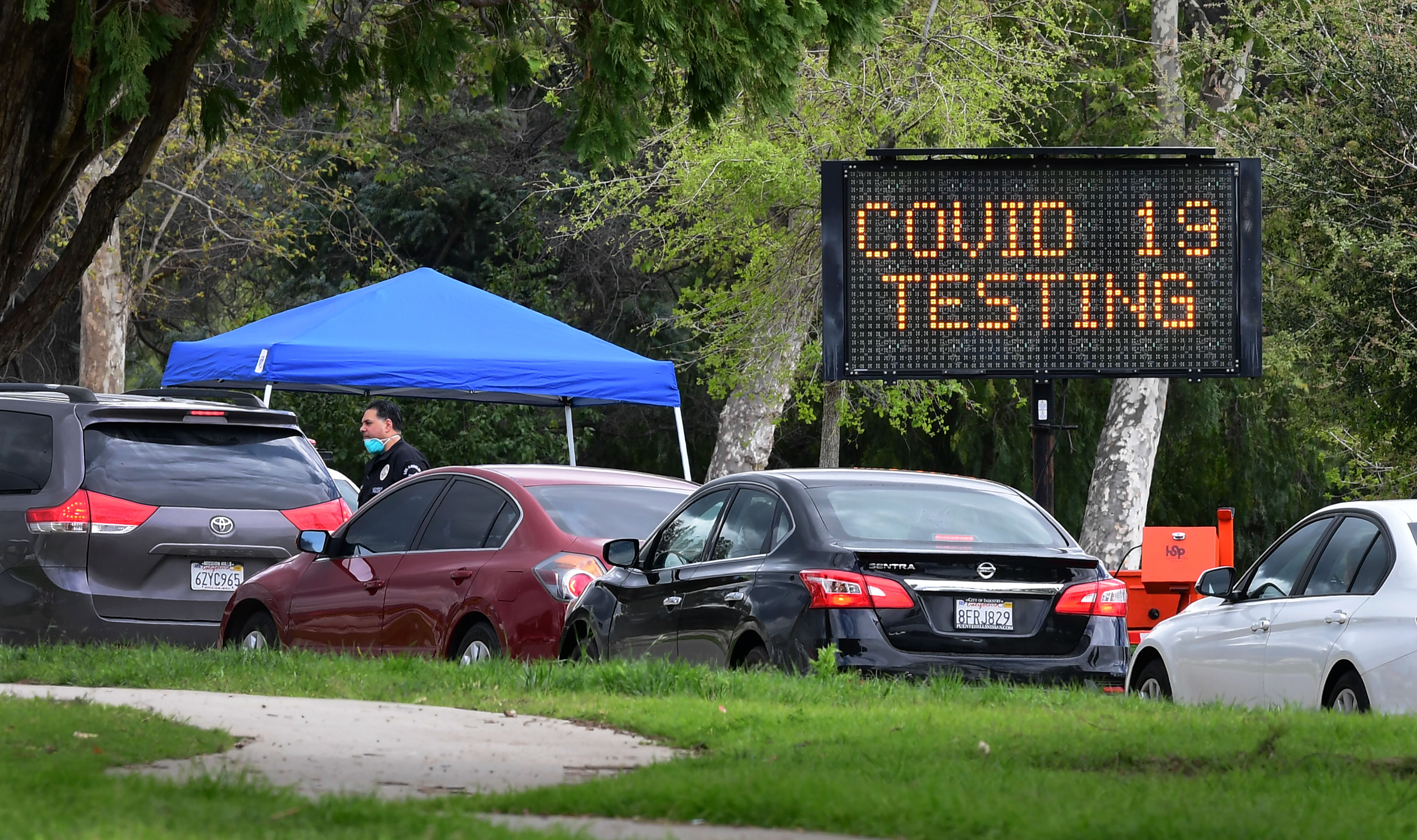 A police officer mans the entrance to a coronavirus testing center in Hansen Dam Park on March 25, 2020, in Pacoima, California. (FREDERIC J. BROWN/AFP via Getty Images)