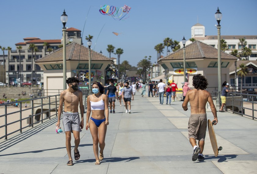 People walk along the Huntington Beach Pier on May 26, 2020, after it opened for the first time since March. (Scott Smeltzer / Times Community News)