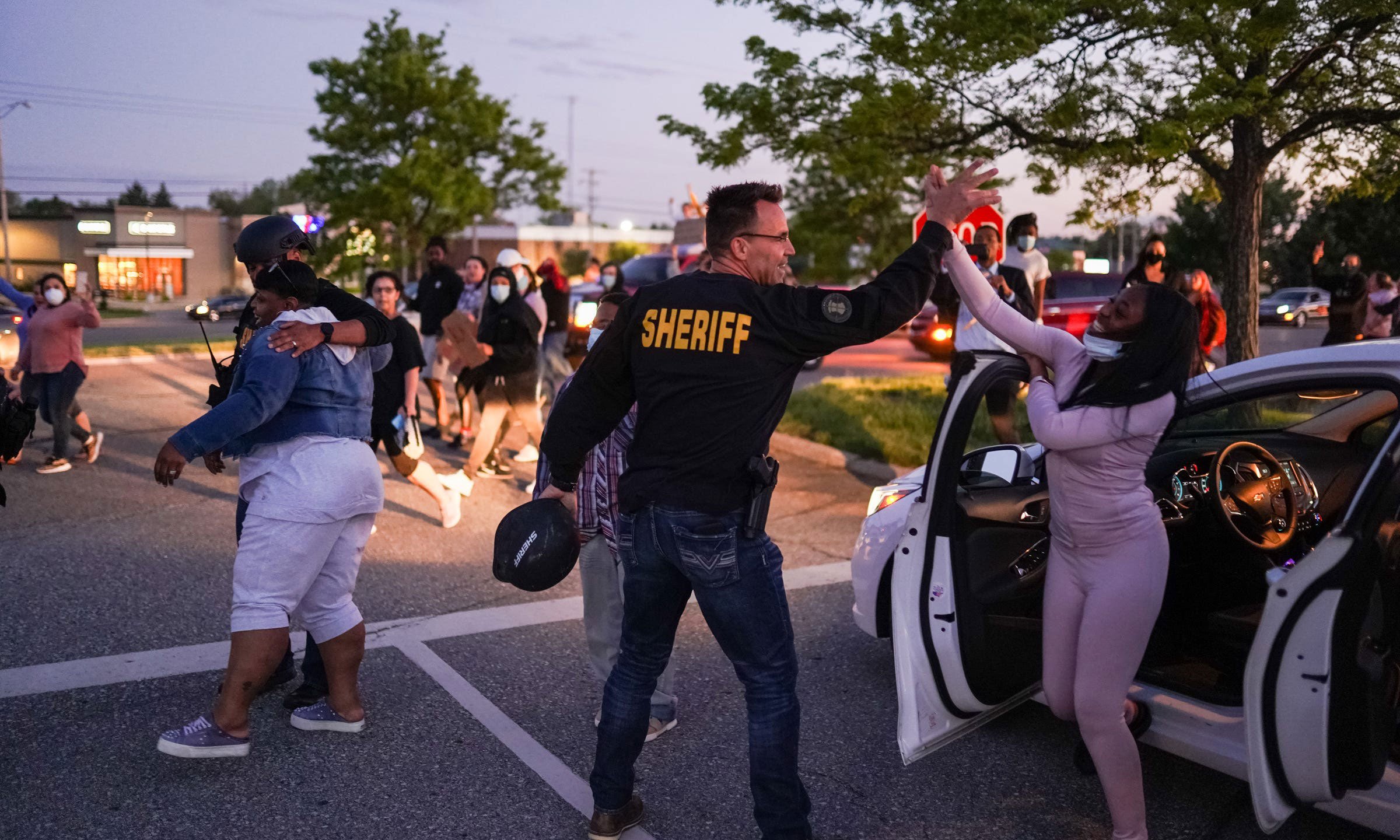 Genesee County Sheriff Chris Swanson high-fives a woman who called his name as he marches with protestors of police brutality and in memory of George Floyd on May 30, 2020, in Flint Township, Michigan. (Ryan Garza/USA Today Network via Reuters)