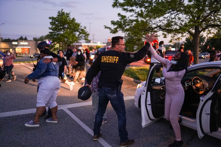 Genesee County Sheriff Chris Swanson high-fives a woman who called his name as he marches with protestors of police brutality and in memory of George Floyd on May 30, 2020, in Flint Township, Michigan. (Ryan Garza/USA Today Network via Reuters)