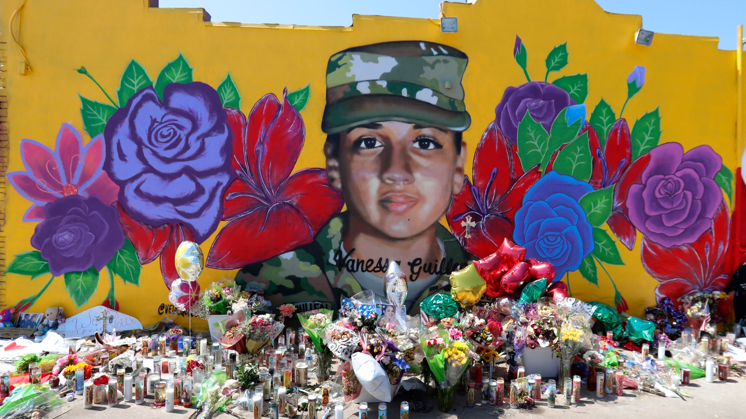 Offerings sit in front of a mural of slain Army Spc. Vanessa Guillen painted on a wall in the south side of Fort Worth, Texas on July 11, 2020. (AP Photo/LM Otero)