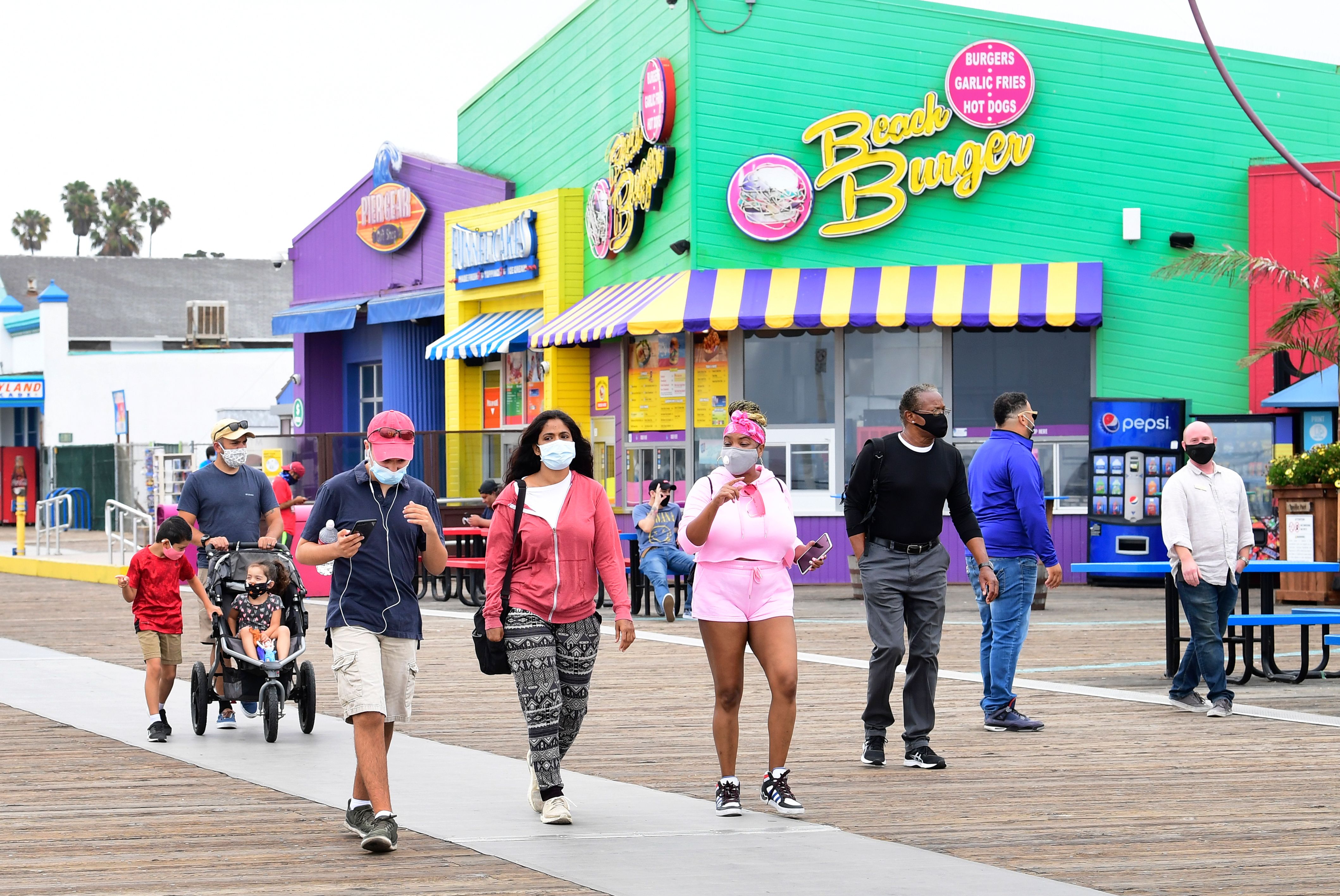 People wearing facemasks visit Santa Monica Pier after it closed for over three months due to the coronavirus pandemic, on June 26, 2020.(FREDERIC J. BROWN/AFP via Getty Images)