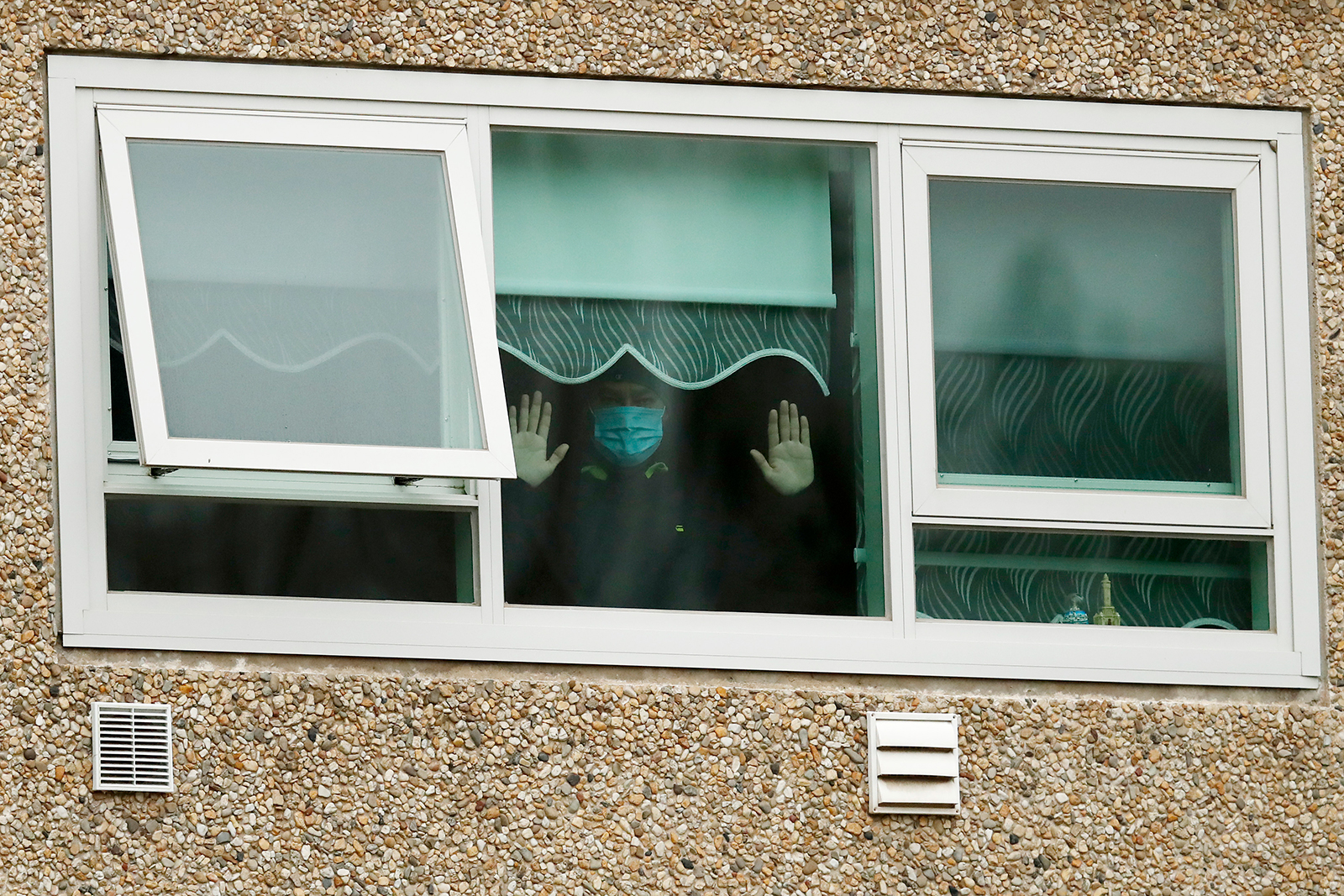 A man is seen looking out a window of the Flemington Towers Government Housing complex on July 06, 2020 in Melbourne, Australia. (Darrian Traynor/Getty Images)