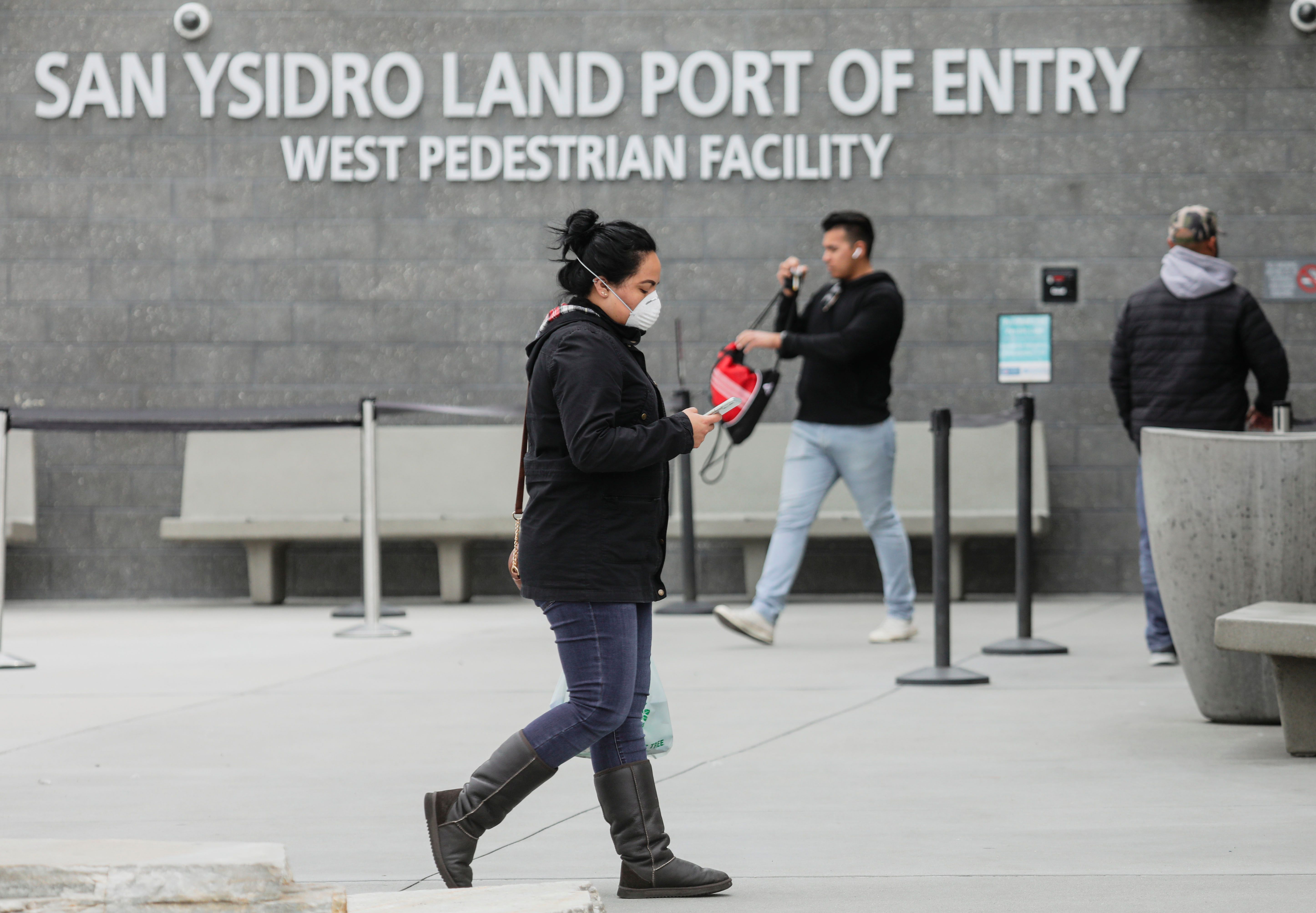 Pedestrians walk out of the United States Port of Entry after coming from Mexico in San Ysidro on March 20, 2020. (SANDY HUFFAKER/AFP via Getty Images)