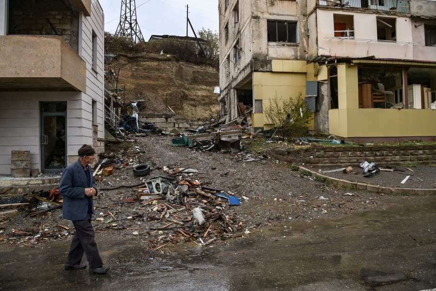 An elderly man walks past destroyed buildings in the breakaway Nagorno-Karabakh region's main city of Stepanakert on Oct. 6, 2020, during the ongoing fighting between Armenia and Azerbaijan over the disputed region. (ARIS MESSINIS/AFP via Getty Images)