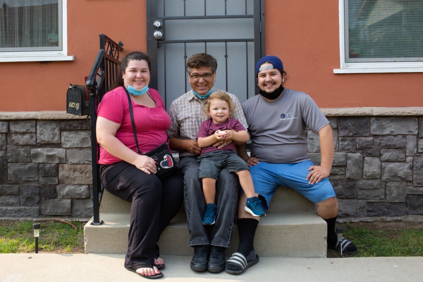 Abel Mata holds his grandson, Milo Walker, while sitting with his daughter, Athena Mata, and son-in-law, Justin Walker, on the patriarch’s front porch in Torrance. (Gabriella Angotti-Jones / Los Angeles Times)
