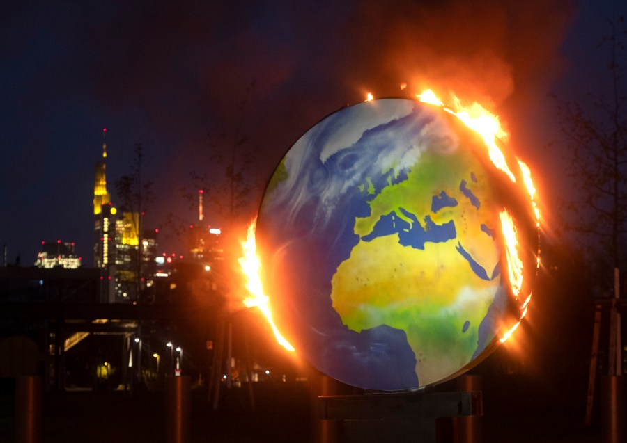 A makeshift globe burns in front of the European Central Bank in Frankfurt, Germany, Wednesday, Oct. 21, 2020. (AP Photo/Michael Probst)