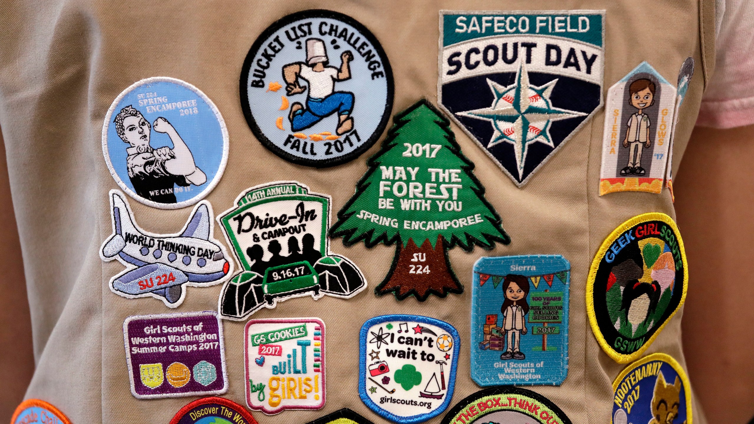 In this June 18, 2018, file photo, patches cover the back of a Girl Scout's vest at a demonstration of some of their activities in Seattle. (Elaine Thompson/AP Photo)