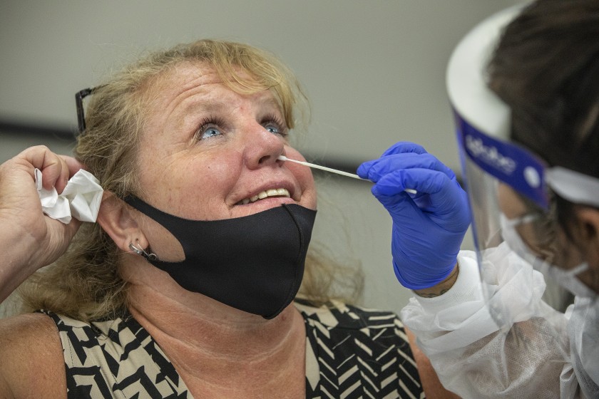 Laurie Goldfinger, left, attendance secretary for Agoura High School, is given a coronavirus test by phlebotomist Jessica Garcia at Wright Middle School in Calabasas.(Mel Melcon / Los Angeles Times)