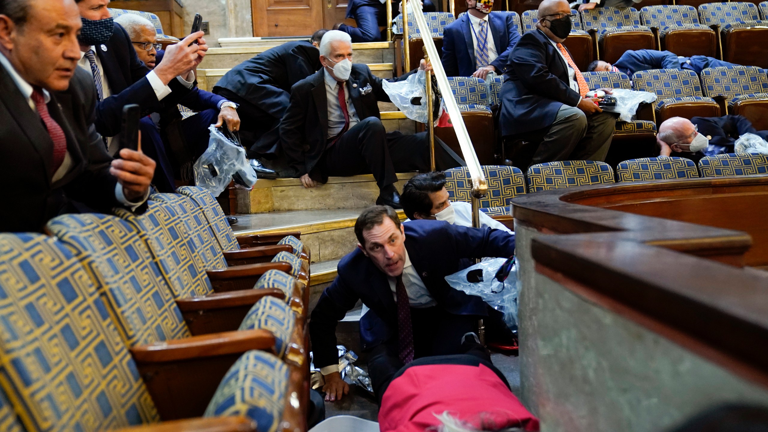 People shelter in the House gallery as protesters try to break into the House Chamber at the U.S. Capitol on Jan. 6, 2021. (Andrew Harnik/Associated Press)