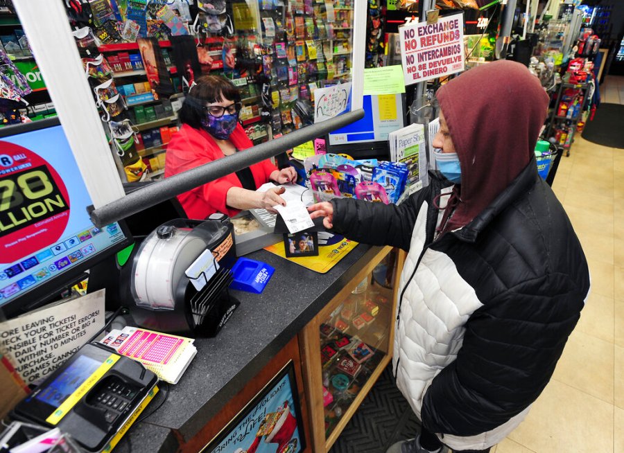 Jacqueline Donahue of Hazleton, right, buys la Mega Millions lottery ticket at the Anthracite Newsstand on Public Square, Monday, Jan. 18, 2021, in Wilkes-Barre, Pa. (Mark Moran/The Citizens' Voice via AP)