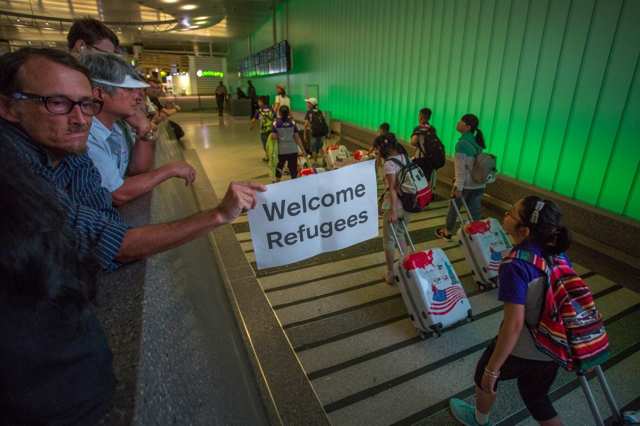 This file photo from June 29, 2017 shows a man carrying a welcome sign as international travelers arrive at LAX on the first day of the the partial reinstatement of the Trump travel ban, temporarily barring travelers from six Muslim-majority nations from entering the U.S. (David McNew/Getty Images)