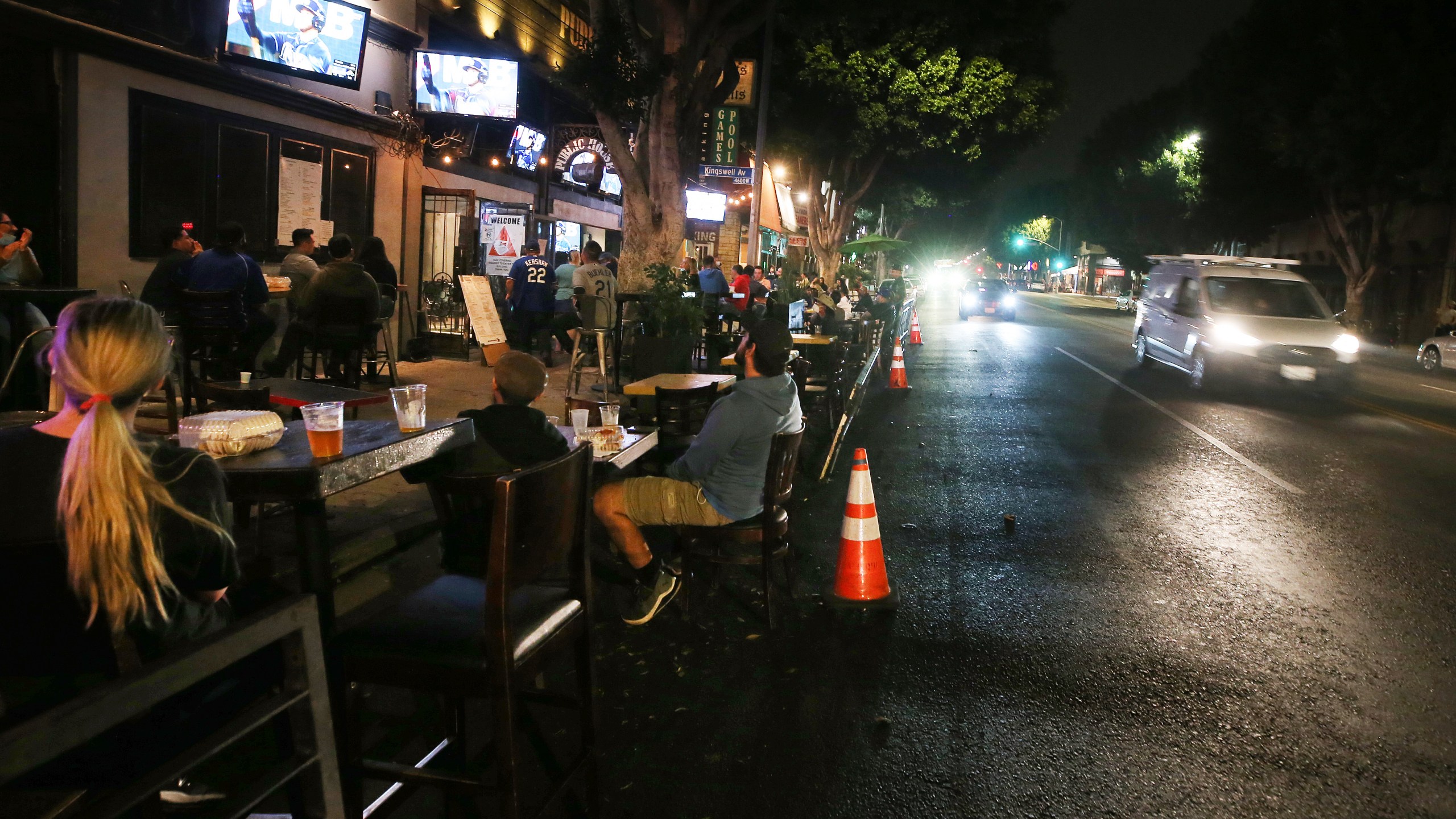 People view a television broadcast of Game 1 of the 2020 World Series between the Los Angeles Dodgers and the Tampa Bay Rays at an outdoor bar and restaurant on Oct. 20, 2020 in Los Angeles. (Mario Tama/Getty Images)