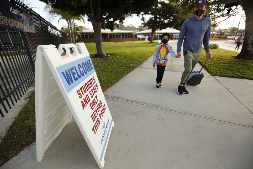 Alik Laddon arrives with his son, first-grader Caden Andino, in 2021 after the reopening of Alta Vista Elementary School in Redondo Beach. (Al Seib / Los Angeles Times)