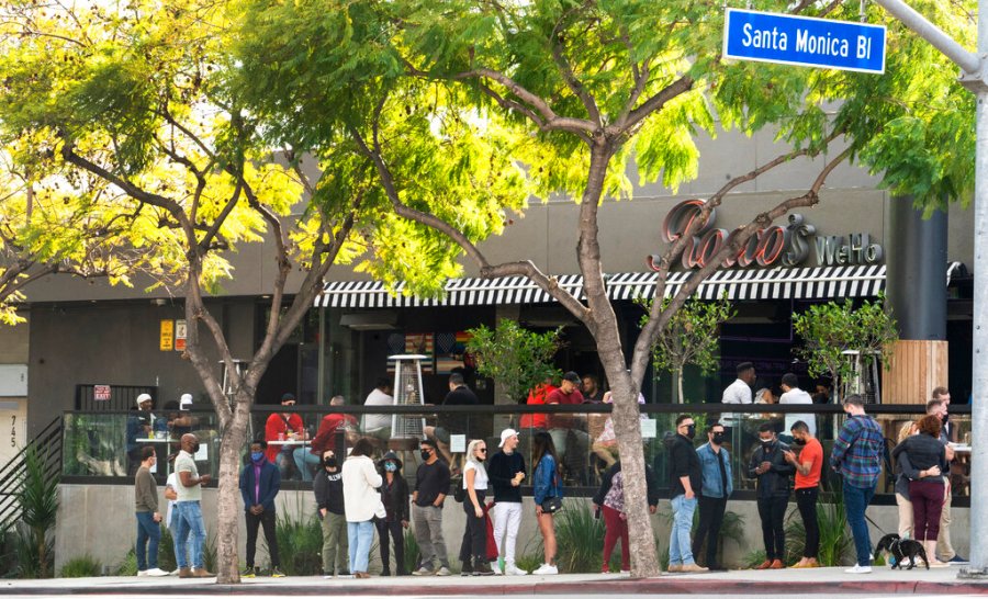 People wait in line for an open terrace table at a restaurant on Valentine's Day on Sunday, Feb. 14, 2021, in West Hollywood, Calif. (AP Photo/Damian Dovarganes)