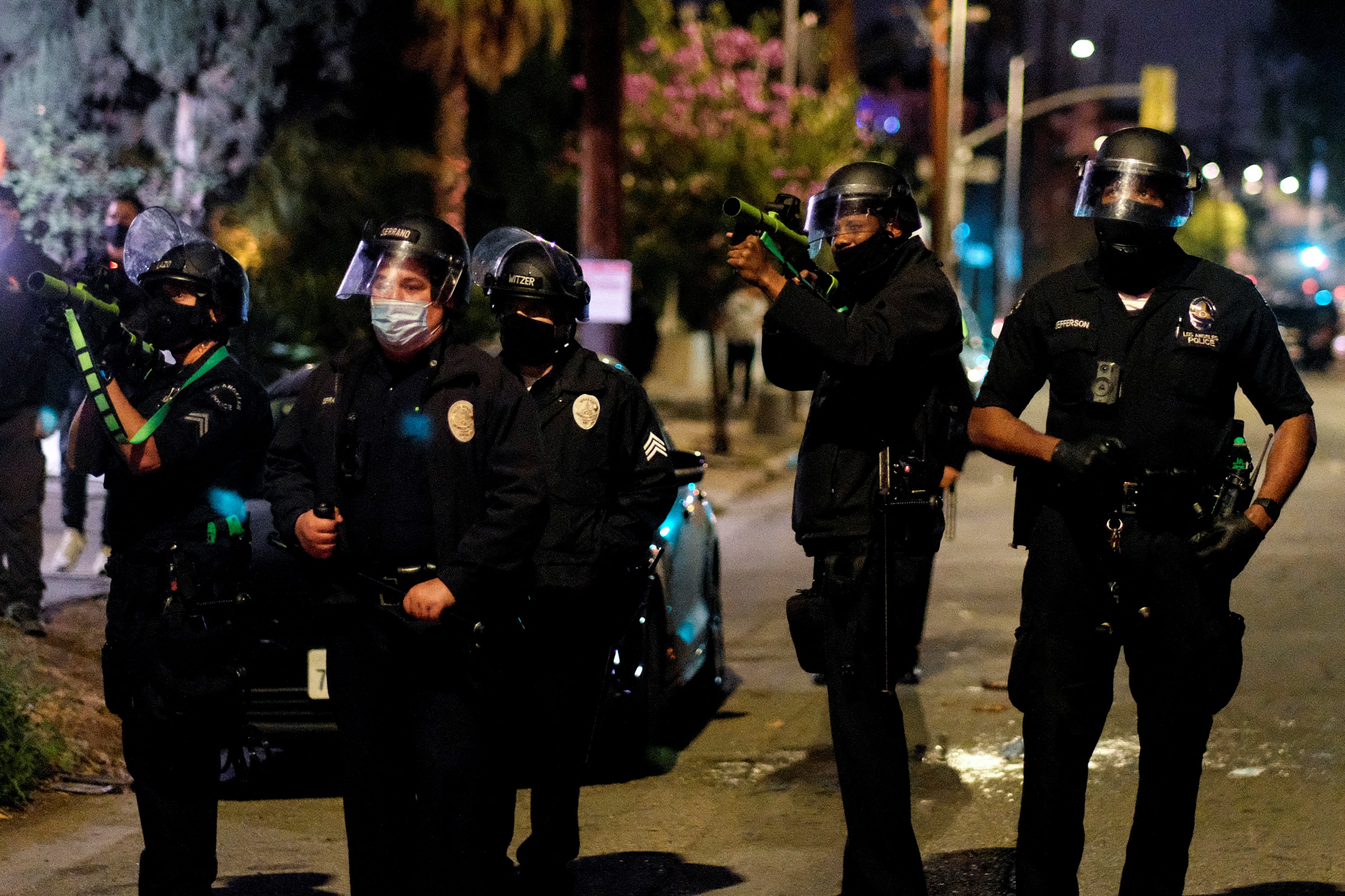 Police point pepper balls guns toward activists and supporters of residents of a homeless encampment at Echo Park Lake in Los Angeles late on March 24, 2021, ahead of a clean-up of the encampment. (RINGO CHIU/AFP via Getty Images)