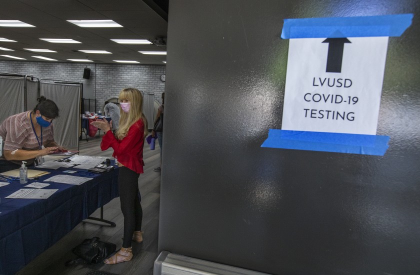 A teacher applies hand sanitizer to her hands while checking in to receive a COVID-19 test at Arthur E. Wright Middle School in Calabasas in this undated photo. (Mel Melcon/Los Angeles Times)