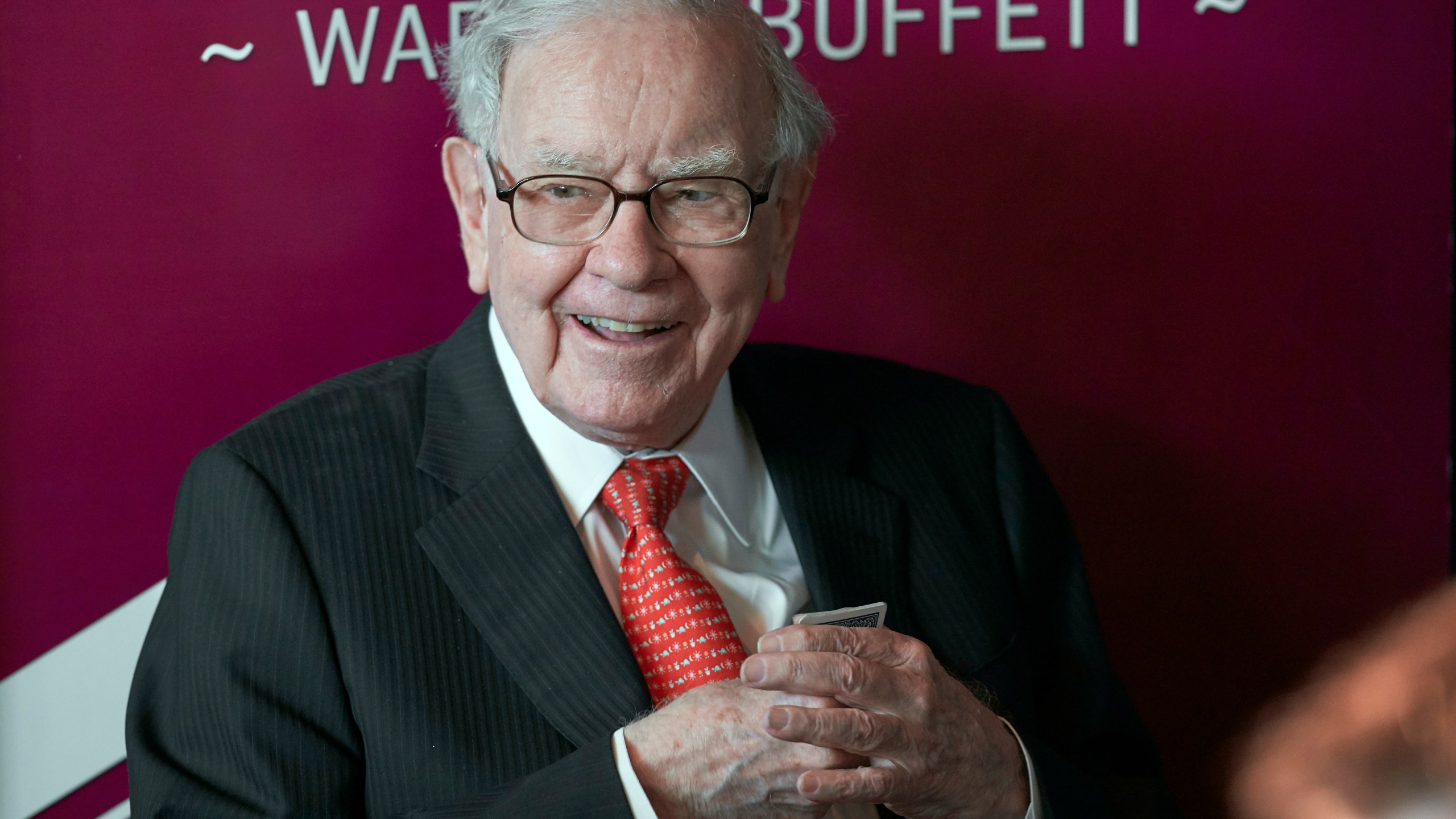 In this May 5, 2019, file photo Warren Buffett, Chairman and CEO of Berkshire Hathaway, smiles as he plays bridge following the annual Berkshire Hathaway shareholders meeting in Omaha, Neb. Buffett will spend Saturday afternoon fielding questions at Berkshire Hathaway's annual meeting, which is being held virtually. (AP Photo/Nati Harnik, File)