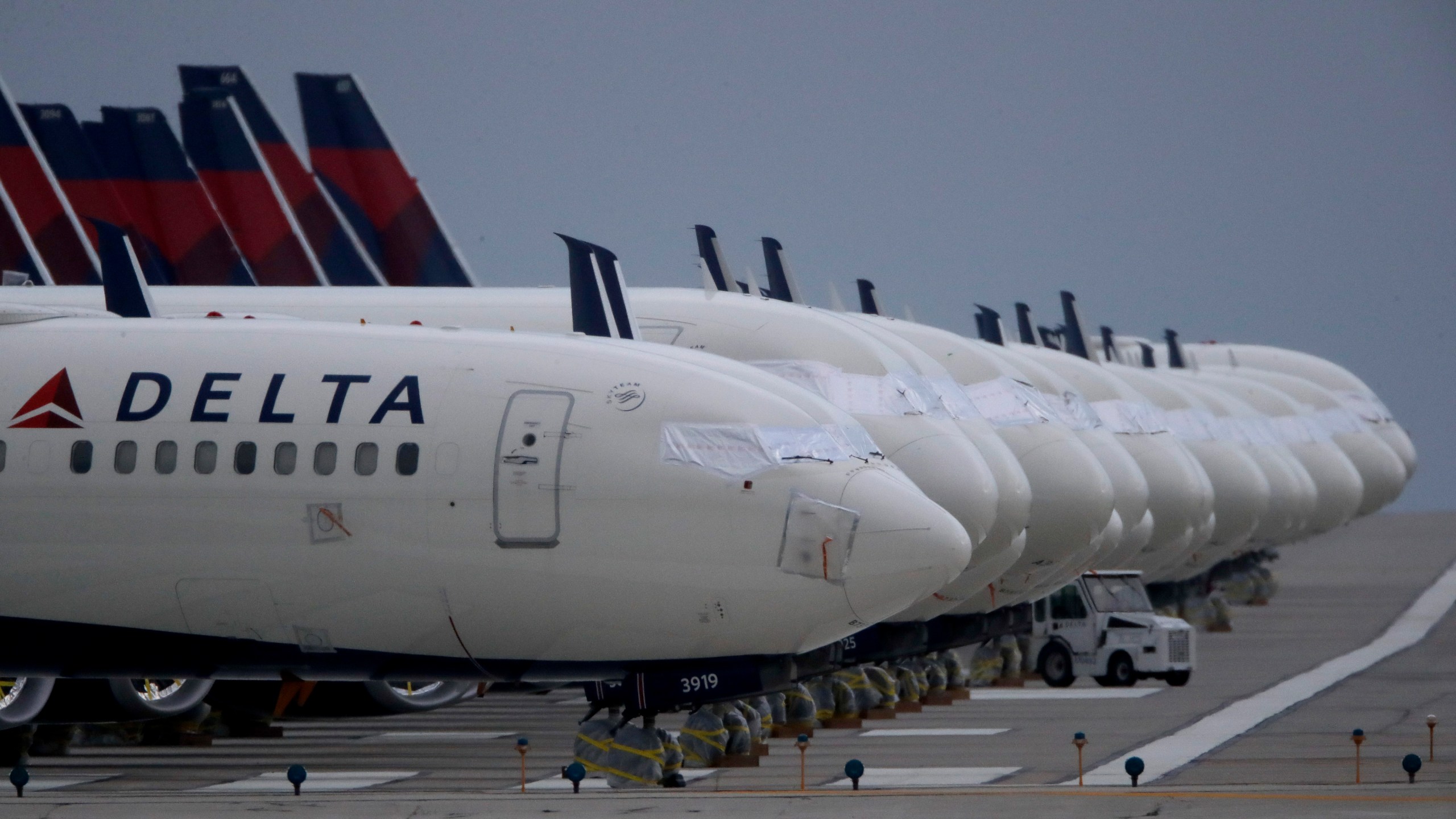 In this May 14, 2020 file photo, several dozen mothballed Delta Air Lines jets are parked on a closed runway at Kansas City International Airport in Kansas City, Mo. (AP Photo/Charlie Riedel, File)