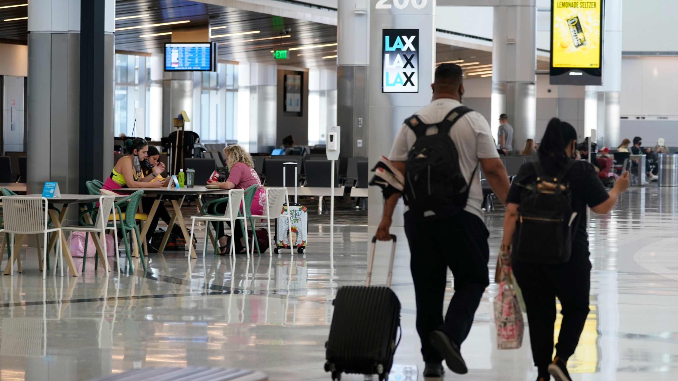 Passengers wait for their flights inside the new West Gates at Tom Bradley International Terminal at Los Angeles International Airport on May 24, 2021. (Ashley Landis / Associated Press)