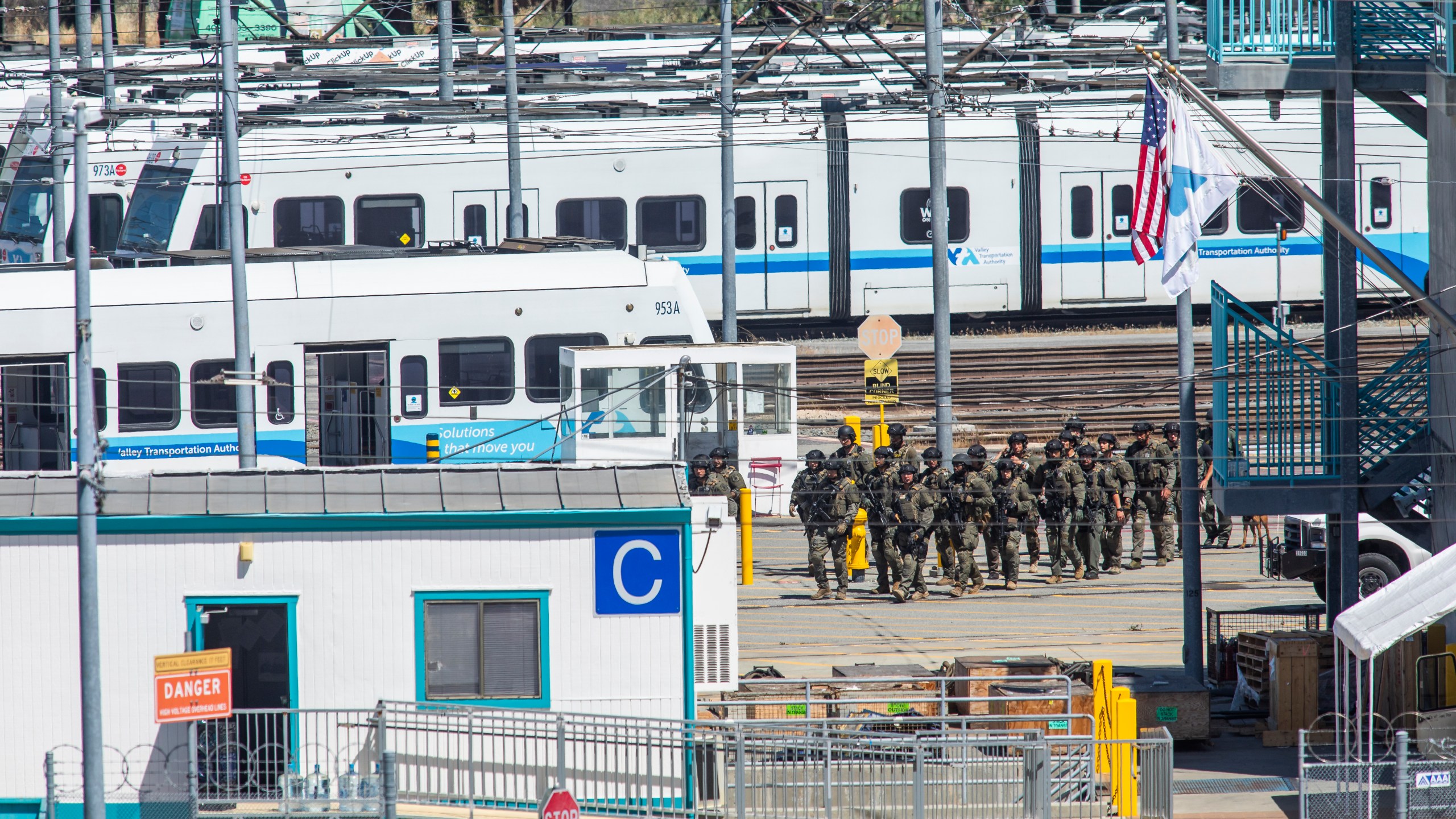 Tactical law enforcement officers move through the Valley Transportation Authority (VTA) light-rail yard where a mass shooting occurred on May 26, 2021 in San Jose, California. A VTA employee opened fire at the yard, with preliminary reports indicating nine people dead including the gunman. (Philip Pacheco/Getty Images)