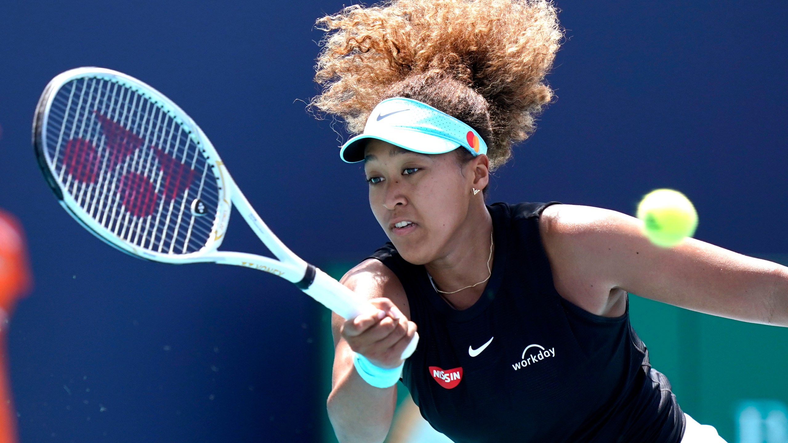 In this March 31, 2021 file photo, Naomi Osaka, of Japan, returns to Maria Sakkari, of Greece, during the quarterfinals of the Miami Open tennis tournament in Miami Gardens, Fla. Sponsors of Osaka are sticking by the her after she withdrew from the French Open, citing mental health issues relating to the press conferences required for players. Osaka, a four-time Grand Slam champion, said Monday, May 31, she was withdrawing from the French Open for mental health issues. (AP Photo/Lynne Sladky, File)