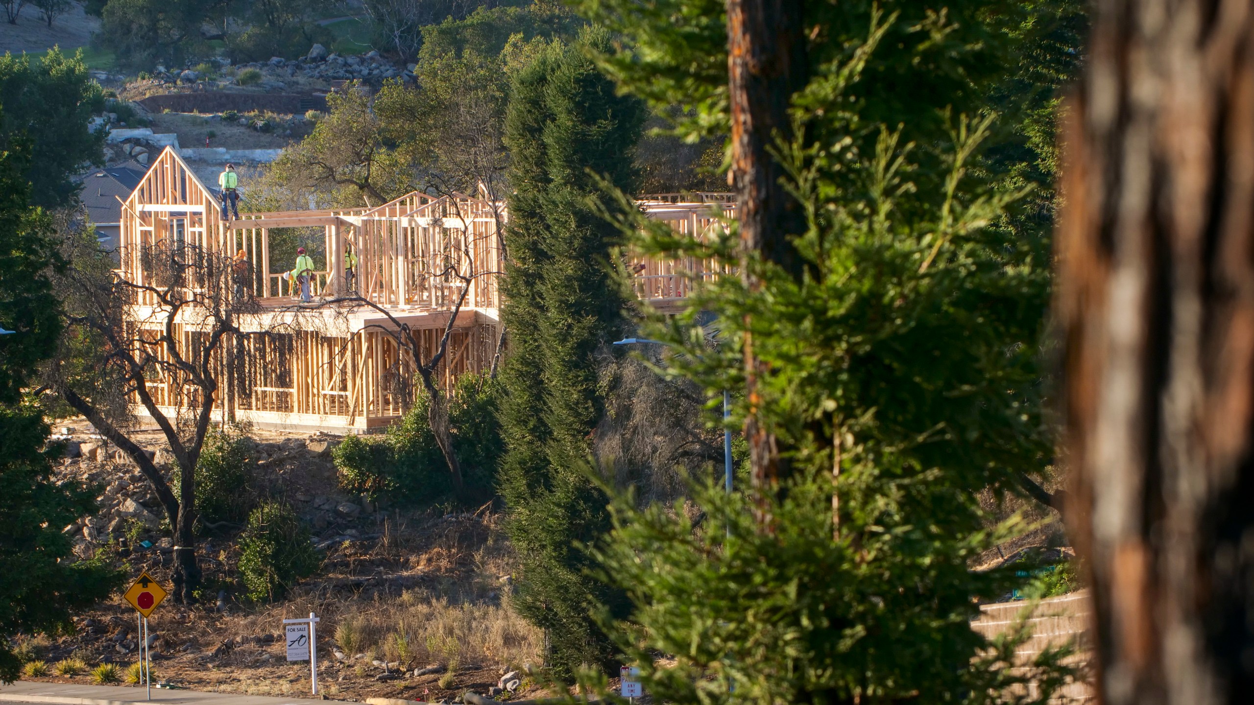 In this Tuesday, Nov. 5, 2019, file photo, builders work on a new home in Santa Rosa, Calif. California state and local officials are incentivizing rebuilding in areas destroyed by wildfires at a time when people should be redirected away from those areas if the state wants to reduce the economic and human impact of increasingly destructive wildfires, according to a report published Thursday, June 10, 2021. (AP Photo/Lacy Atkins, File)