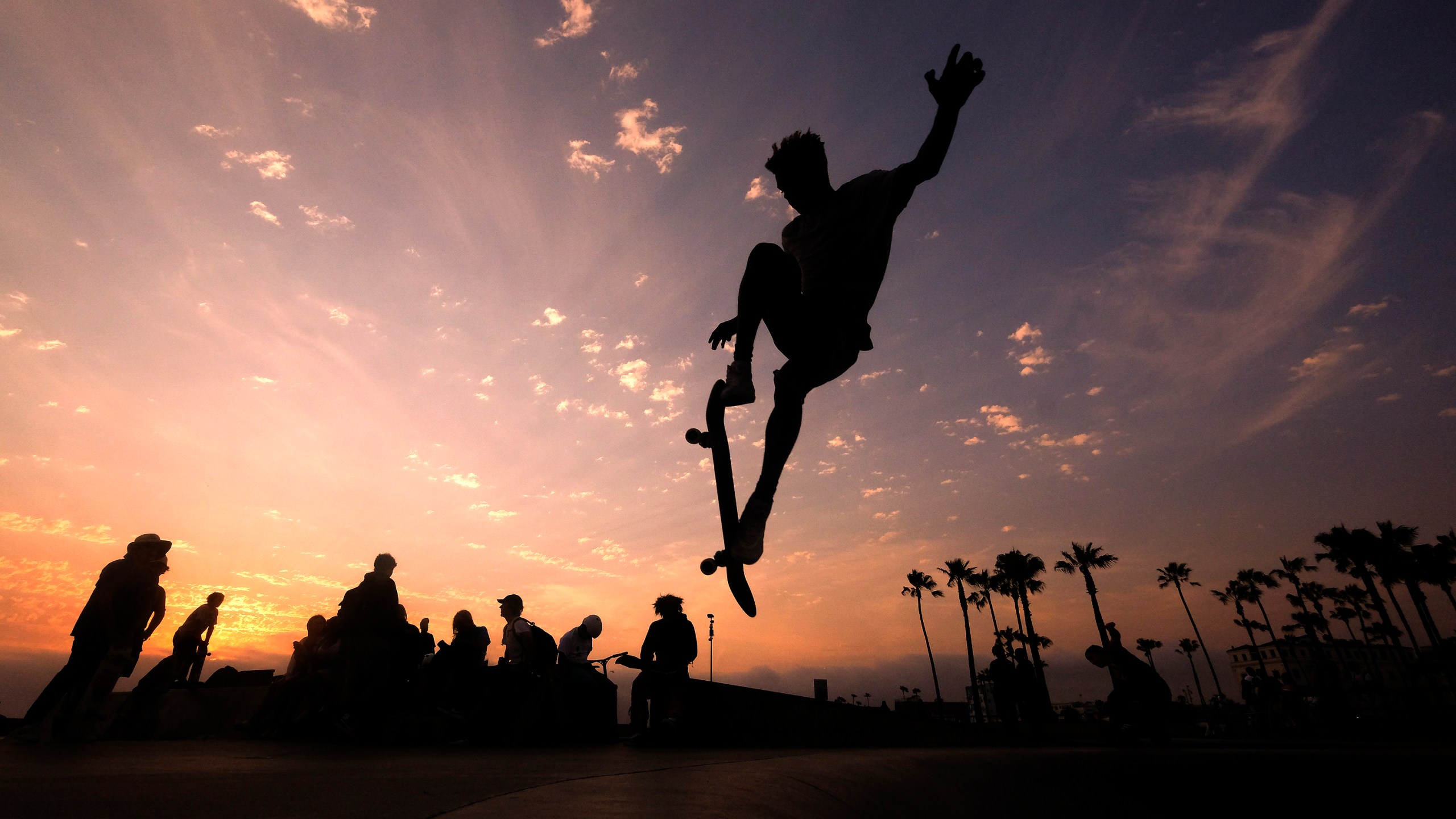 In this Wednesday, June 16, 2021, file photo, a skateboarder is silhouetted as he jumps high at the skateboard park during sunset in the Venice Beach section of Los Angeles. The Southwest U.S. continued to bake Saturday, June 19, and weather forecasters kept warnings in effect for excessive heat in Arizona, Nevada and desert areas, at least through the weekend. (AP Photo/Ringo H.W. Chiu, File)