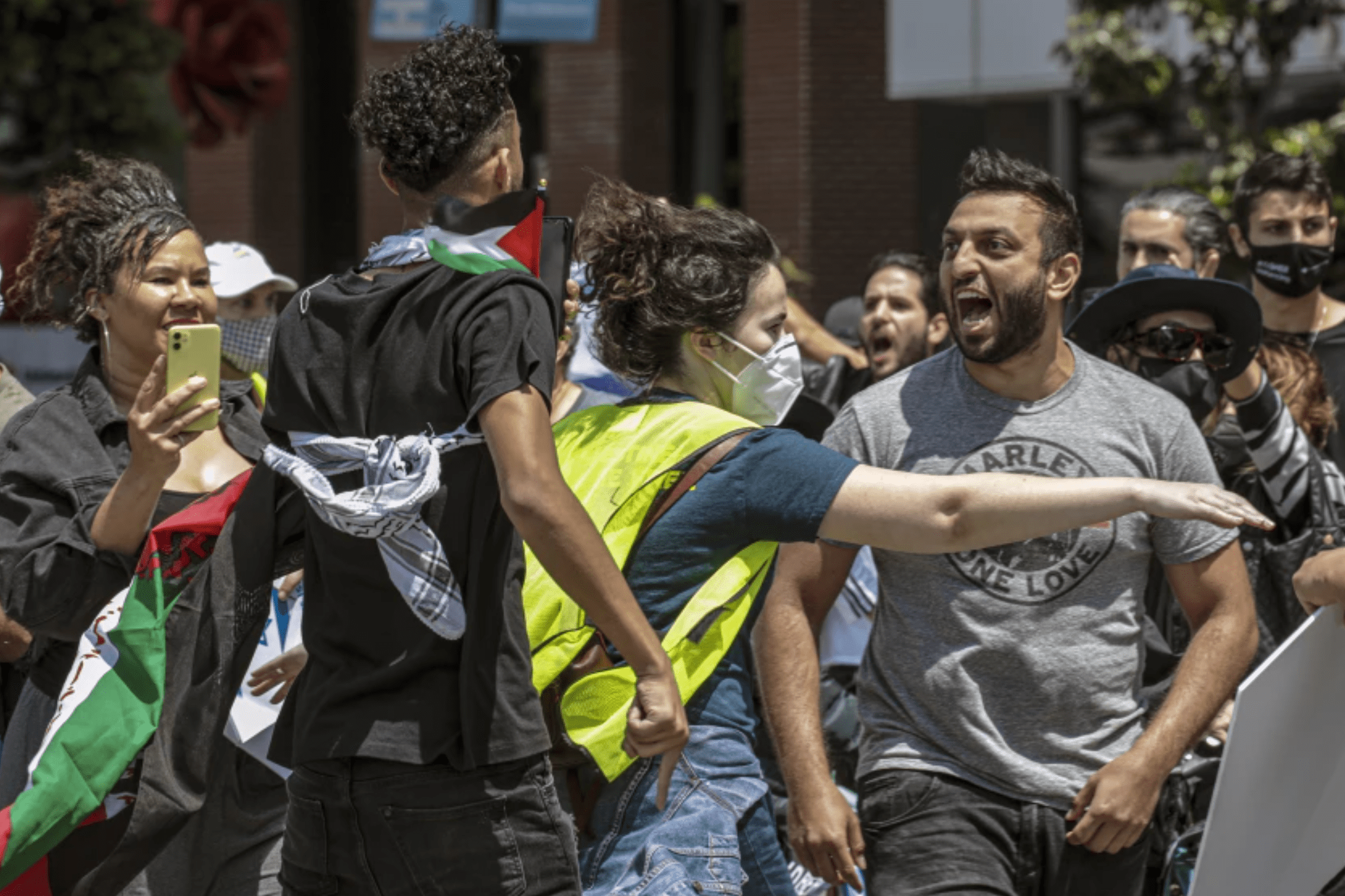 A rally organizer, center, separates a Palestinian supporter, left, and an Israeli supporter, right, at a rally in Los Angeles in May 2021.(Irfan Khan / Los Angeles Times)