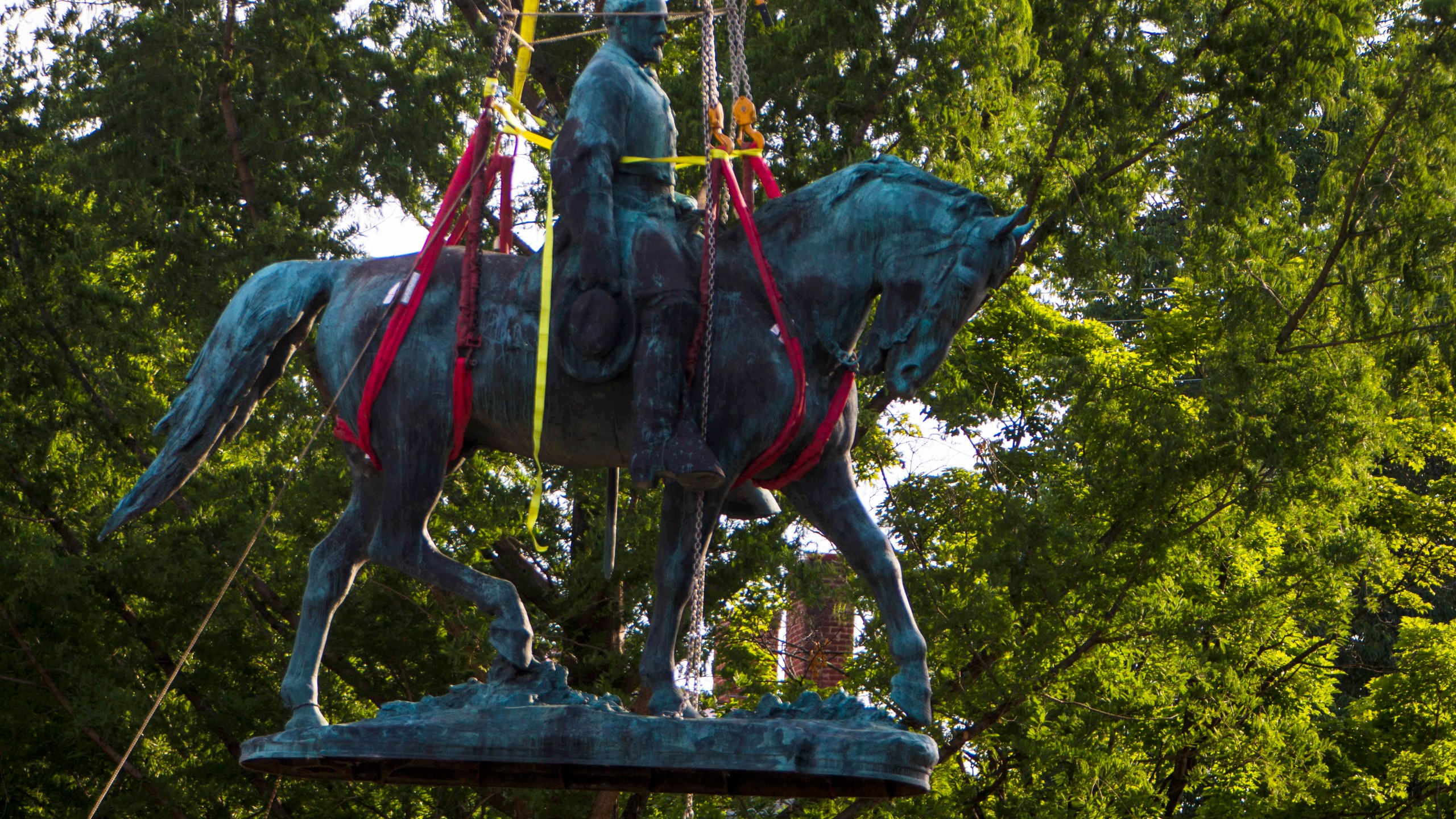 Workers remove the monument of Confederate General Robert E. Lee on Saturday, July 10, 2021 in Charlottesville, Va. (AP Photo/John C. Clark)