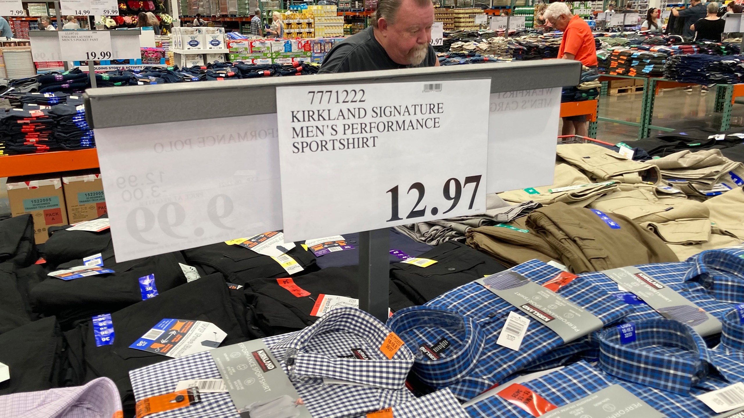 A sign displays the price for shirts as a shopper peruses the offerings at a Costco warehouse on Thursday, June 17, 2021, in Lone Tree, Colo. American consumers faced a third straight monthly surge in princes in June, the latest sign that a rapid reopening of the economy is fueling a pent-up demand for goods and services that in many cases remain in short supply. (AP Photo/David Zalubowski)