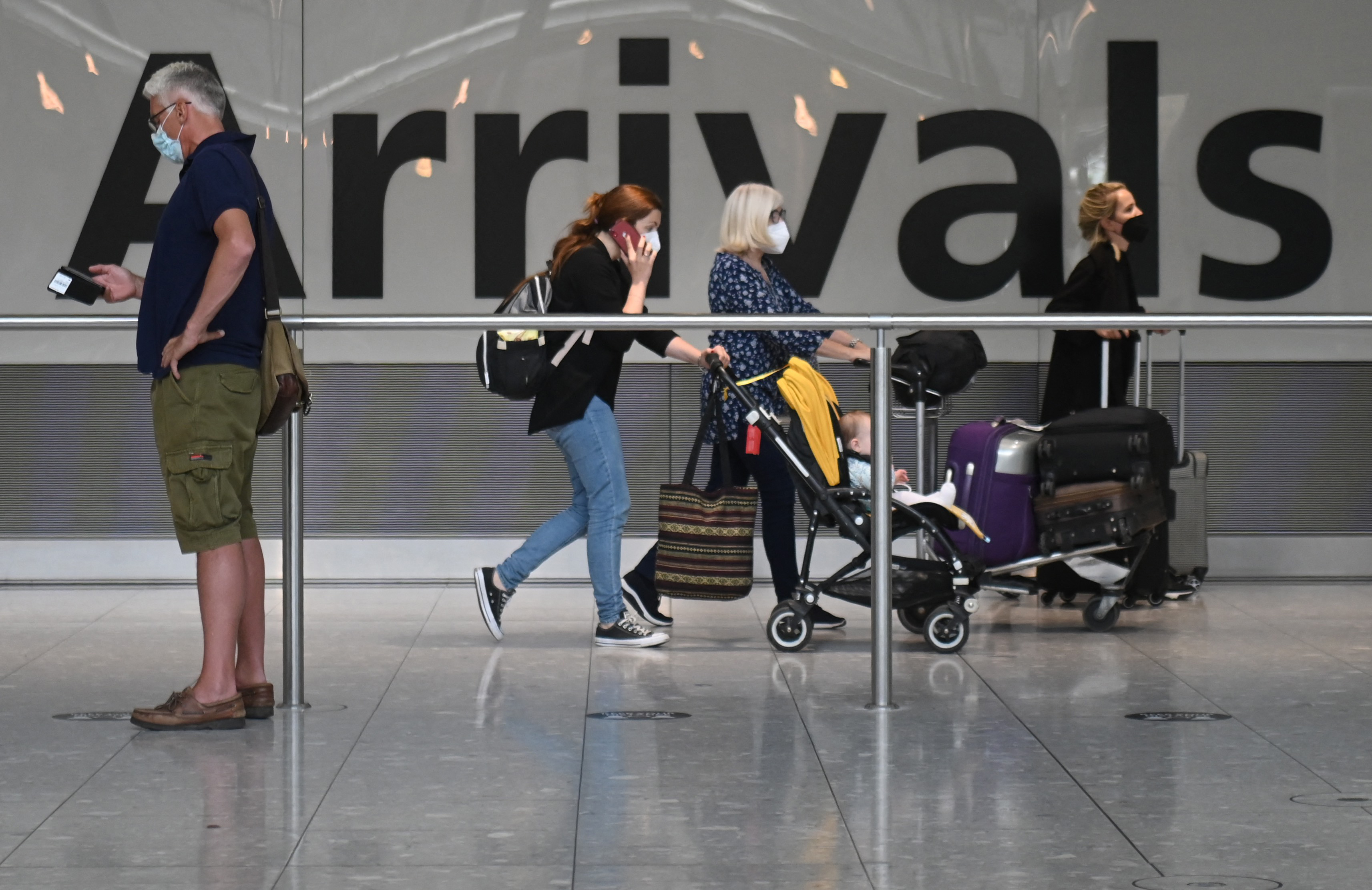 Travelers walk through Heathrow airport in London, on June 3, 2021. (DANIEL LEAL-OLIVAS/AFP via Getty Images)